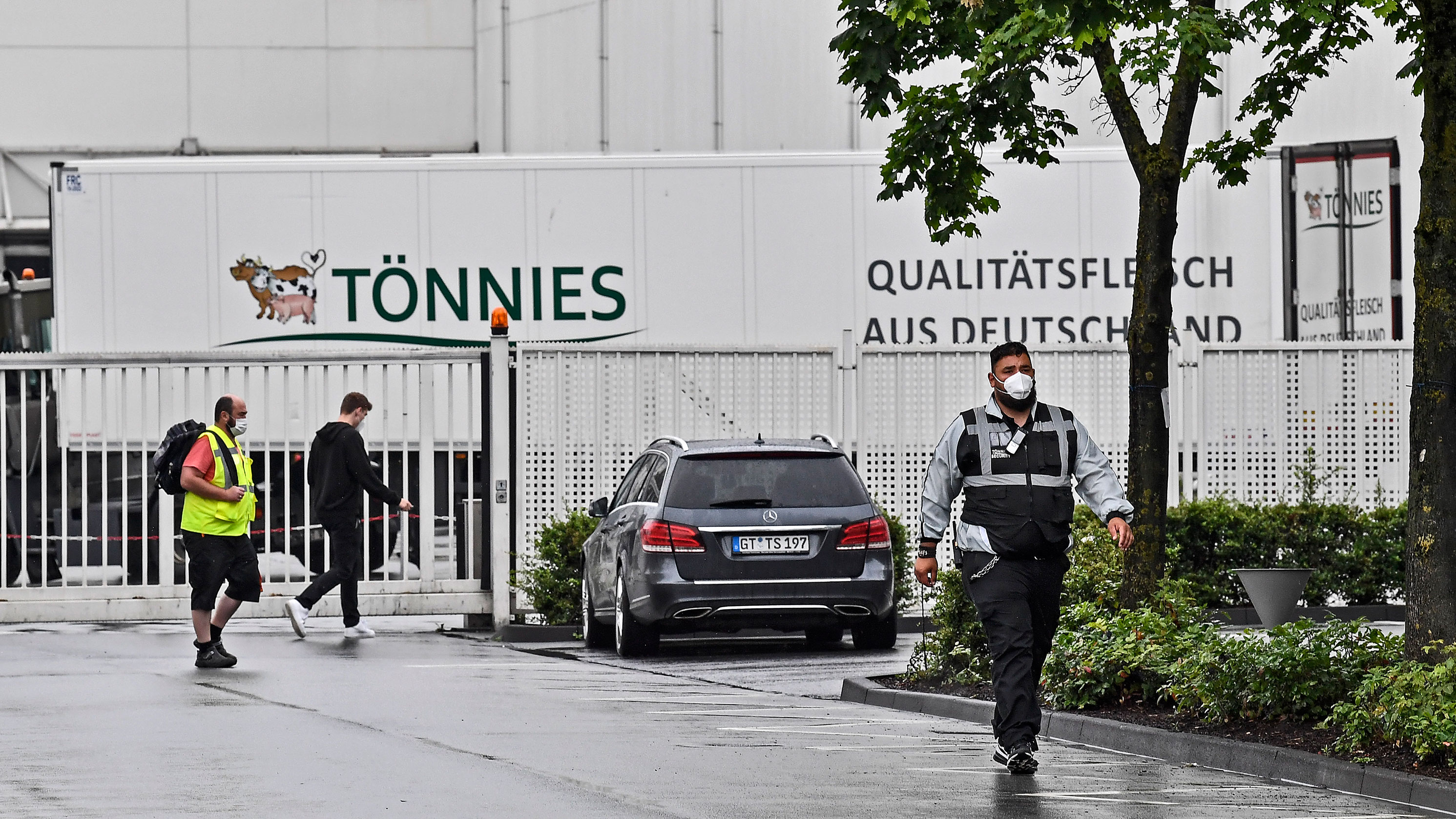 A member of the security walks in front of the Toennies meatpacking plant in Rheda-Wiedenbrueck, Germany, on June 18.
