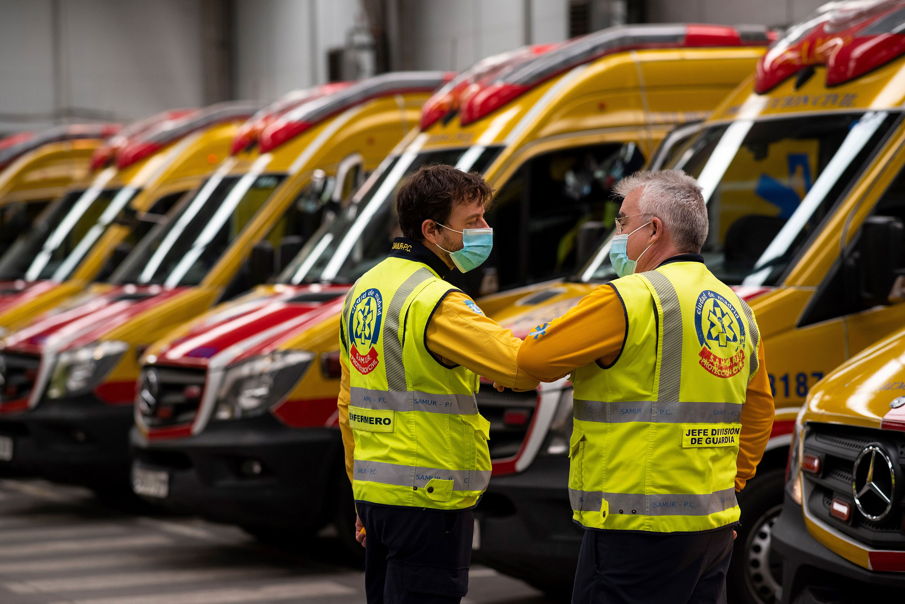 Two members of the Madrid Emergency Medical Service greet each other by touching elbows during a briefing in Madrid on May 15.