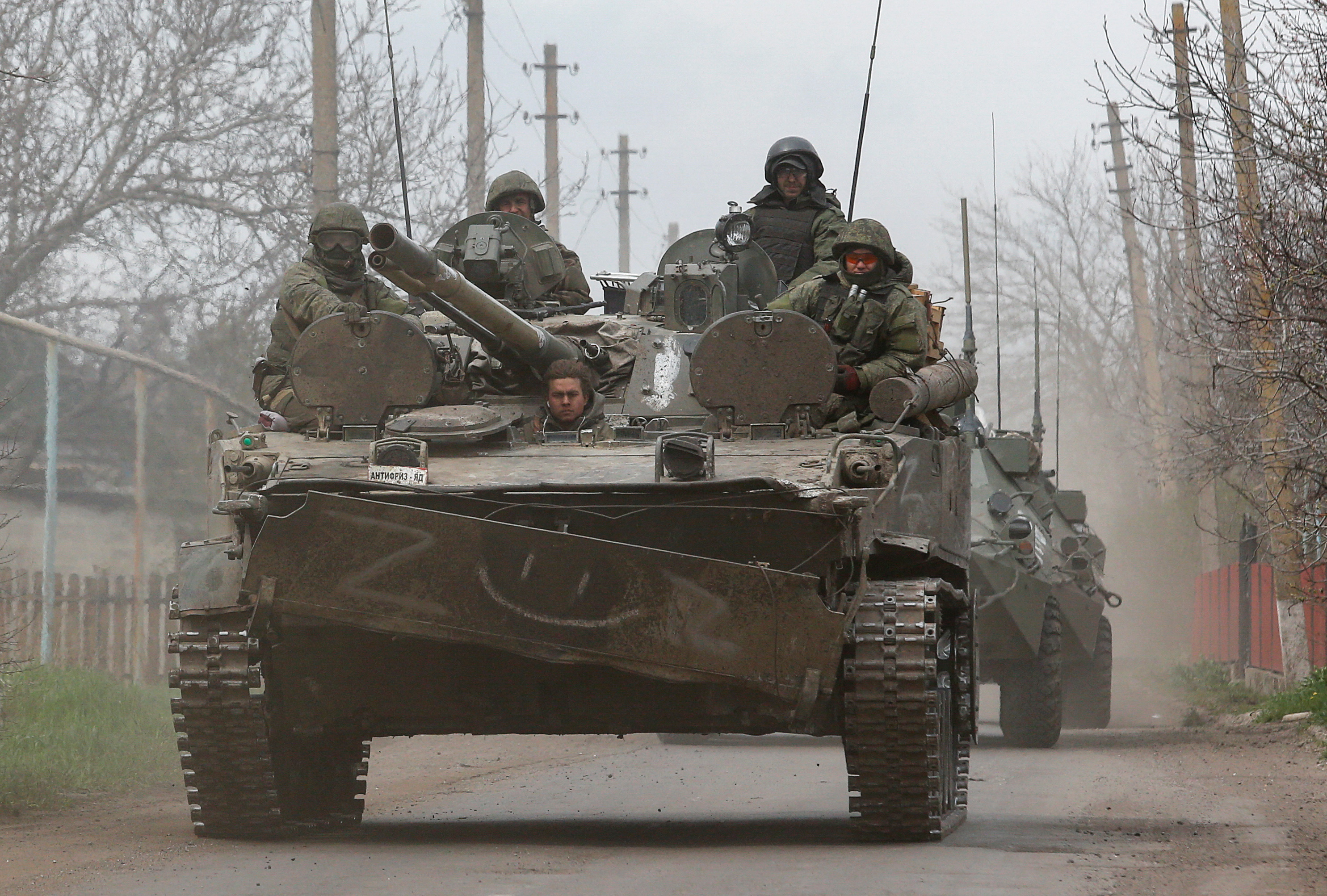 Service members of pro-Russian troops sit atop of an armored vehicle en route to the southern port city of Mariupol, Ukraine, on April 17.