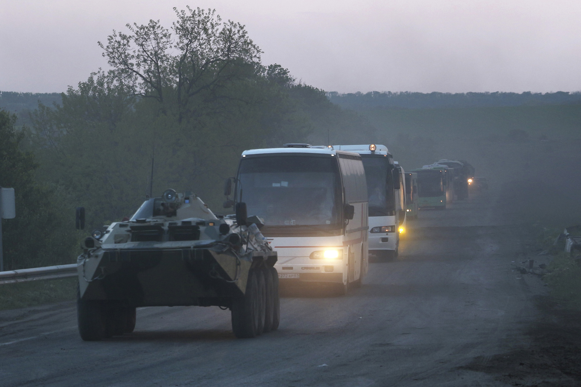 An APC from the Donetsk People's Republic militia accompanies buses with Ukrainian servicemen to the penal colony in Olenivka after they left the besieged Azovstal steel plant in Mariupol, Ukraine on Friday May 20.