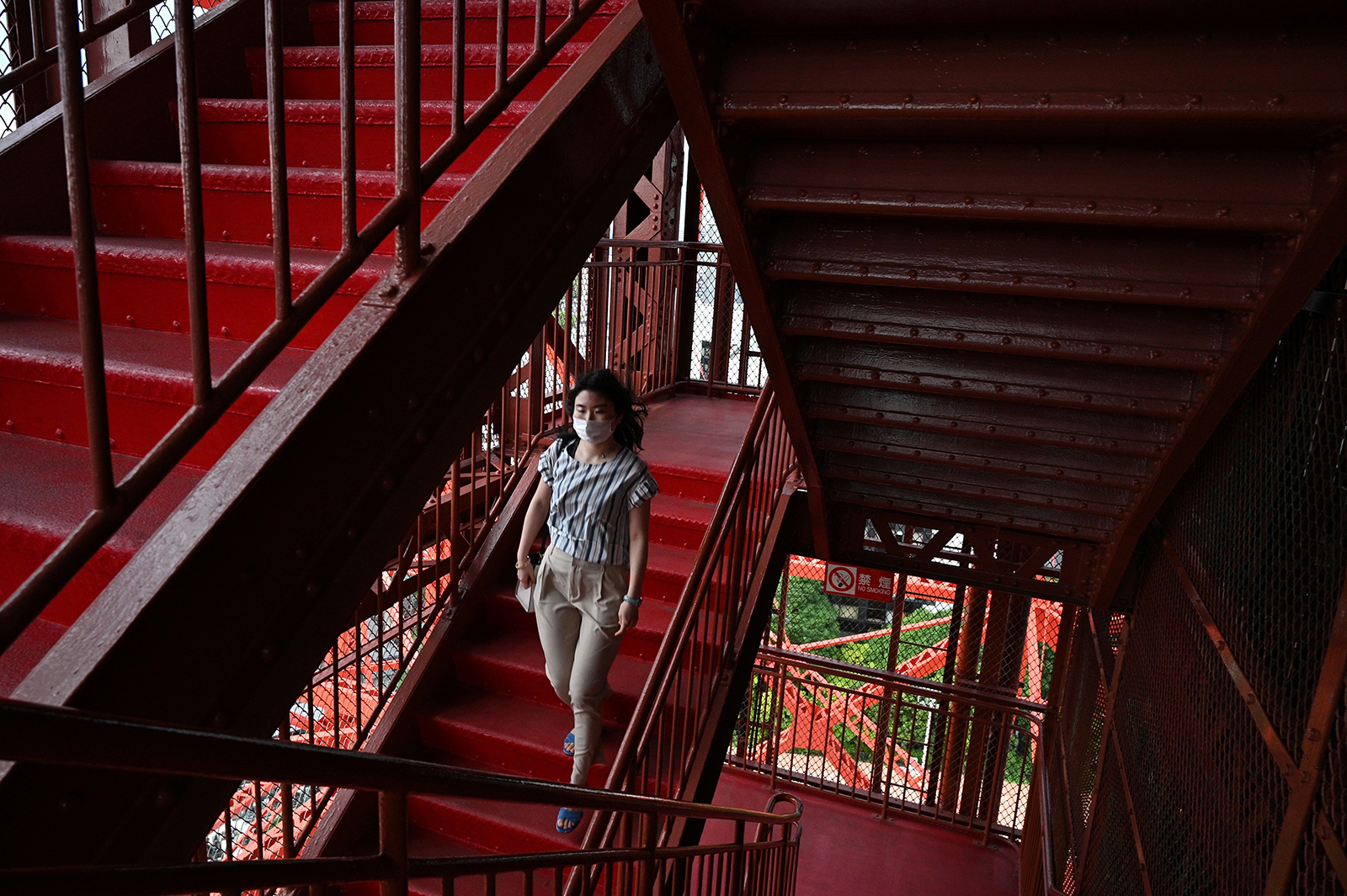 A visitor wearing a face mask walks down the stairs at the Tokyo Tower on May 28 in Tokyo. 