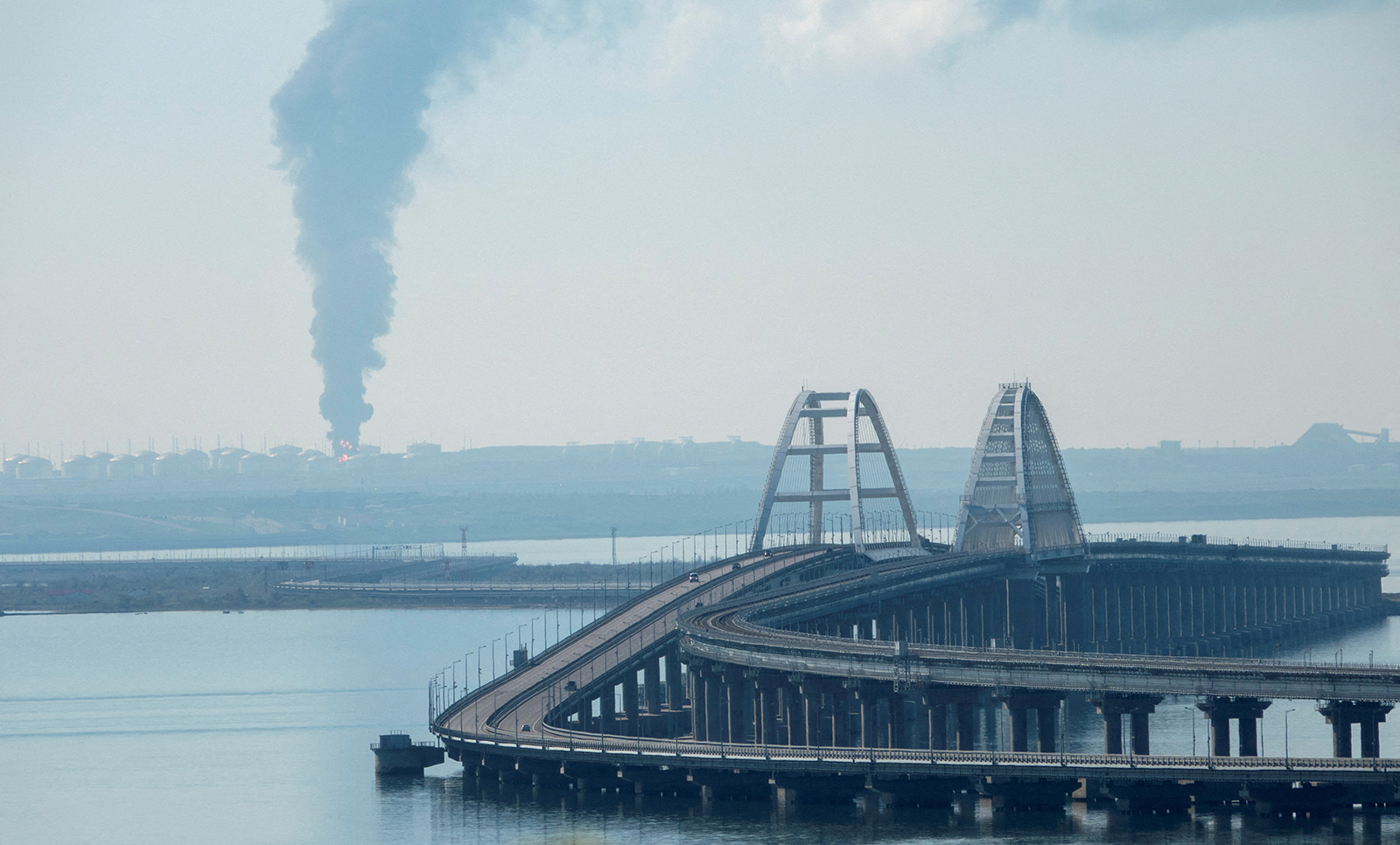 A view across the Kerch Strait shows smoke rising above a fuel depot near the Crimean bridge in the village of Volna in Russia's Krasnodar region as seen from a coastline in Crimea, on May 3.