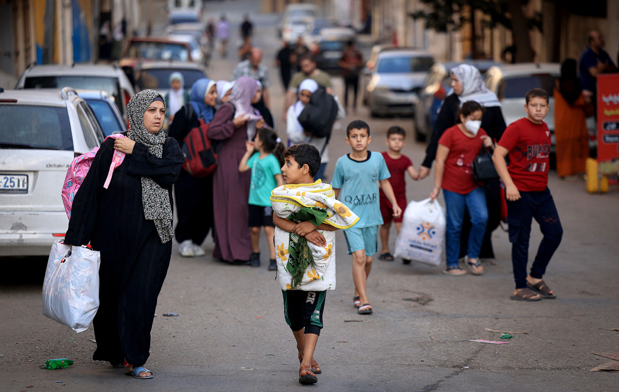 Los palestinos que cargan sus pertenencias huyen a zonas más seguras en la ciudad de Gaza después de los ataques aéreos israelíes, el 13 de octubre de 2023.