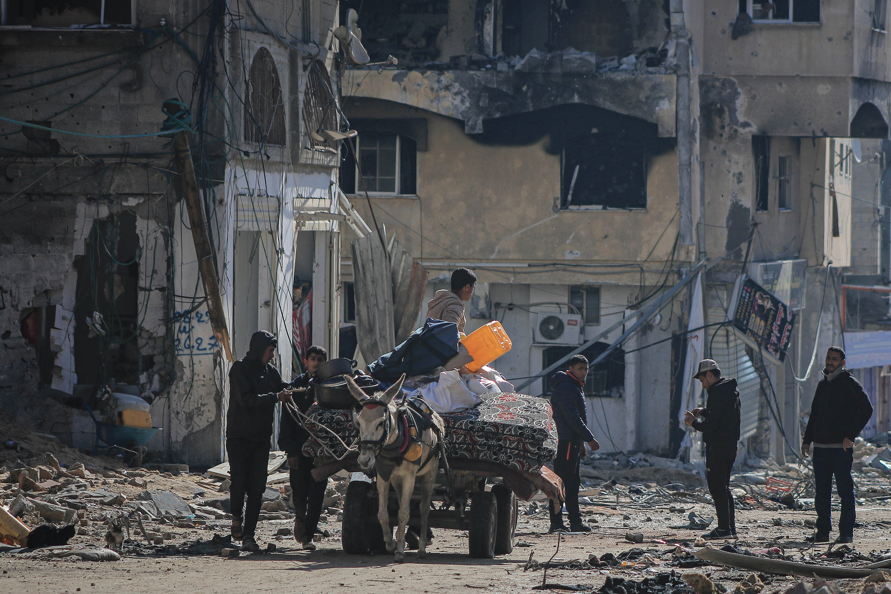 Palestinians with a donkey cart outside destroyed residential buildings in Khan Younis, Gaza, on February 3.