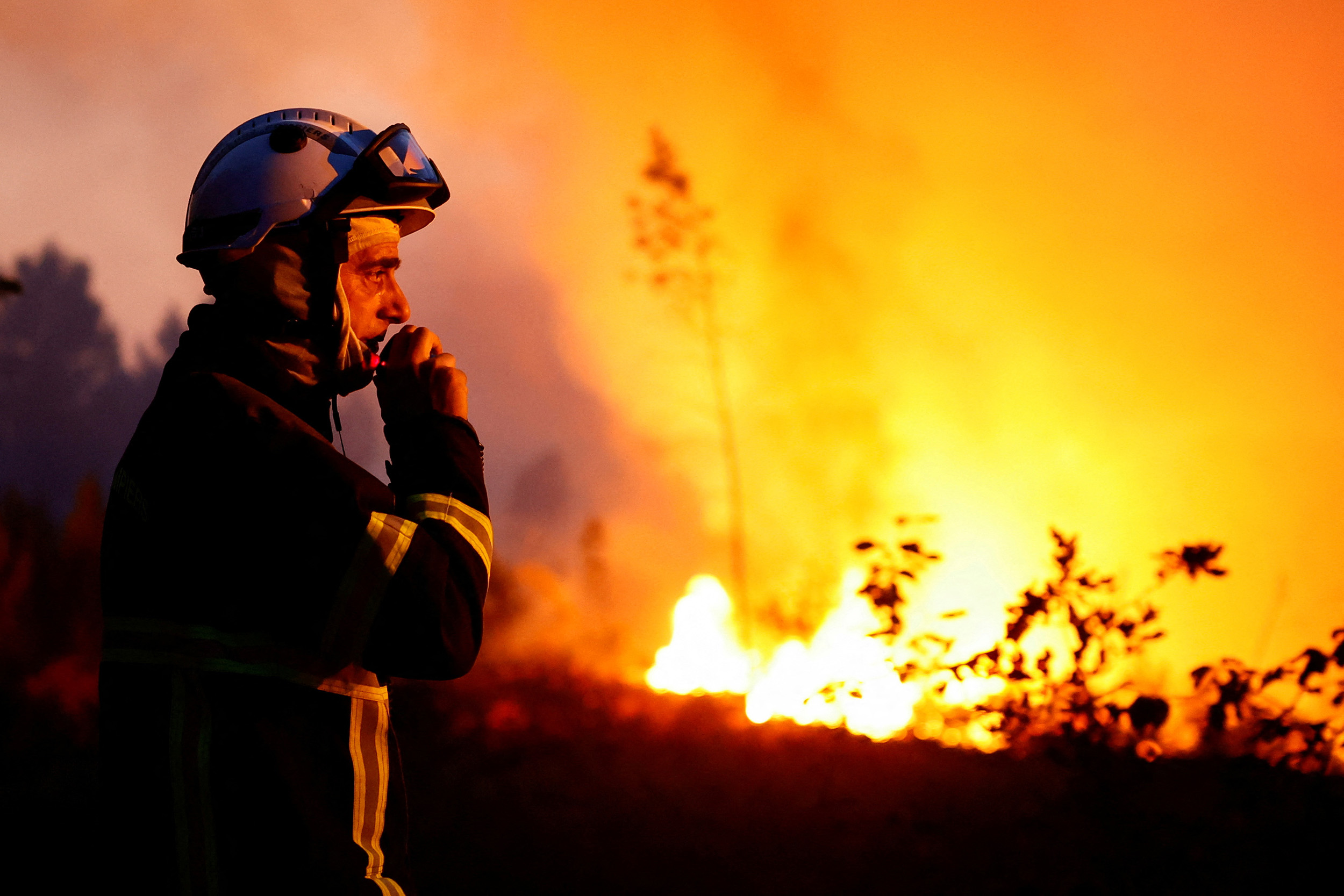 A firefighter watches the flames in Louchats as wildfires continue to spread in the Gironde region of southwestern France, on July 17.