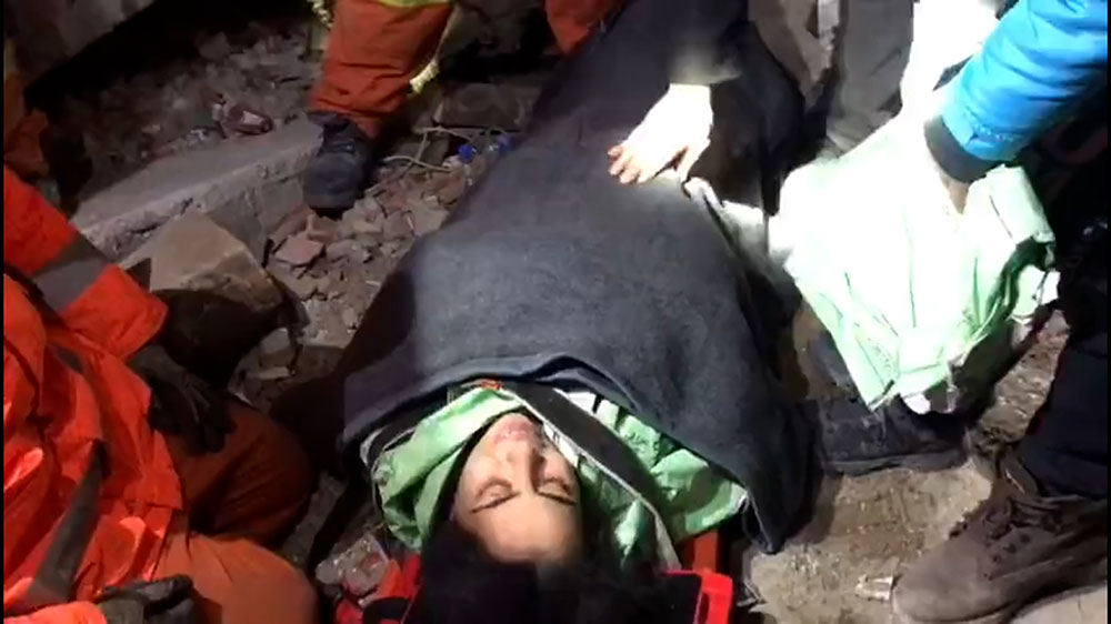 Fatma Demir is seen talking with rescuers after being pulled from the collapsed building. 