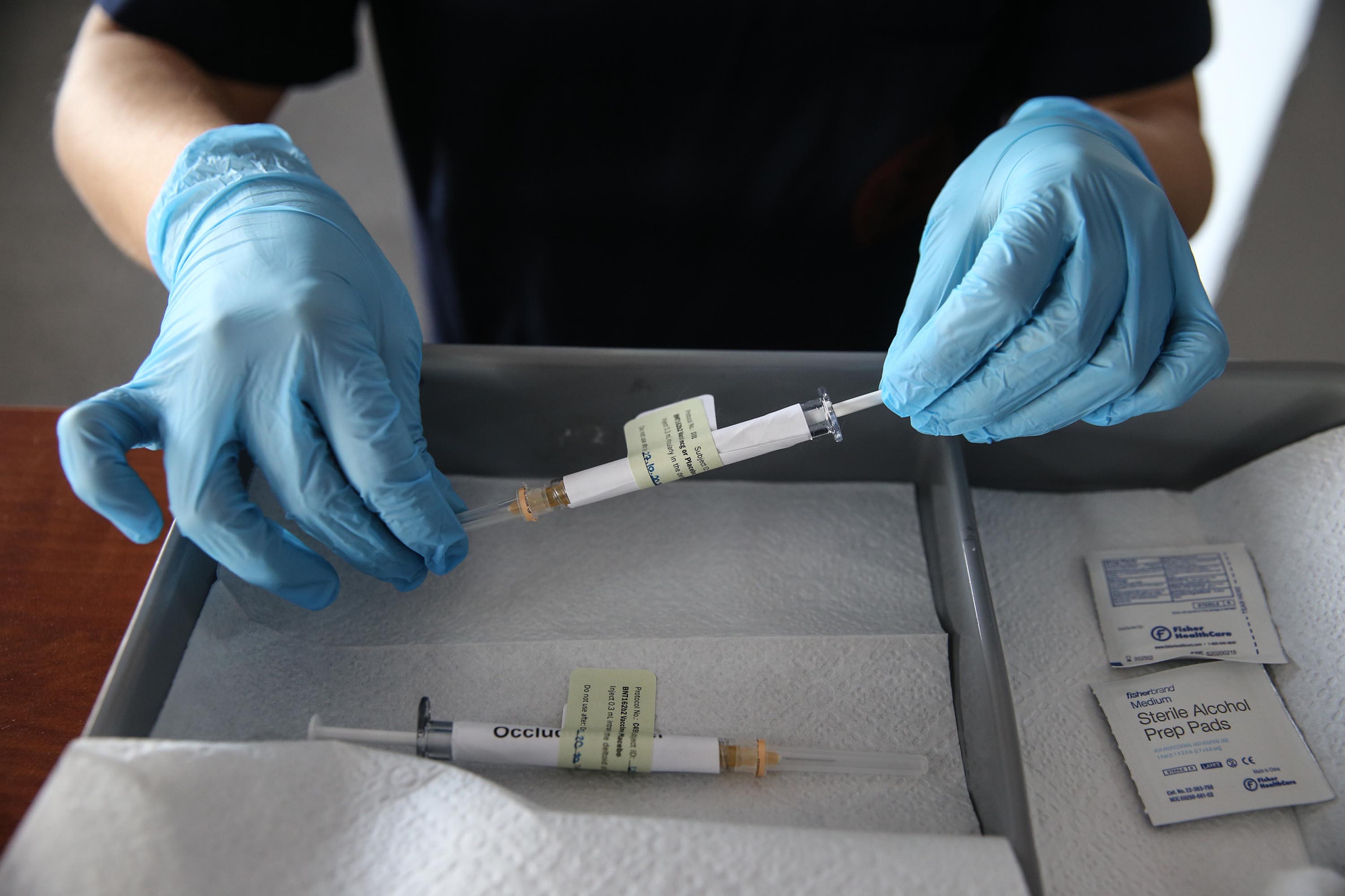 A health care worker holds an injection syringe of the coronavirus phase 3 vaccine trial developed by Pfizer and BioNTech, at the Ankara University Ibni Sina Hospital in Ankara, Turkey on October 27.