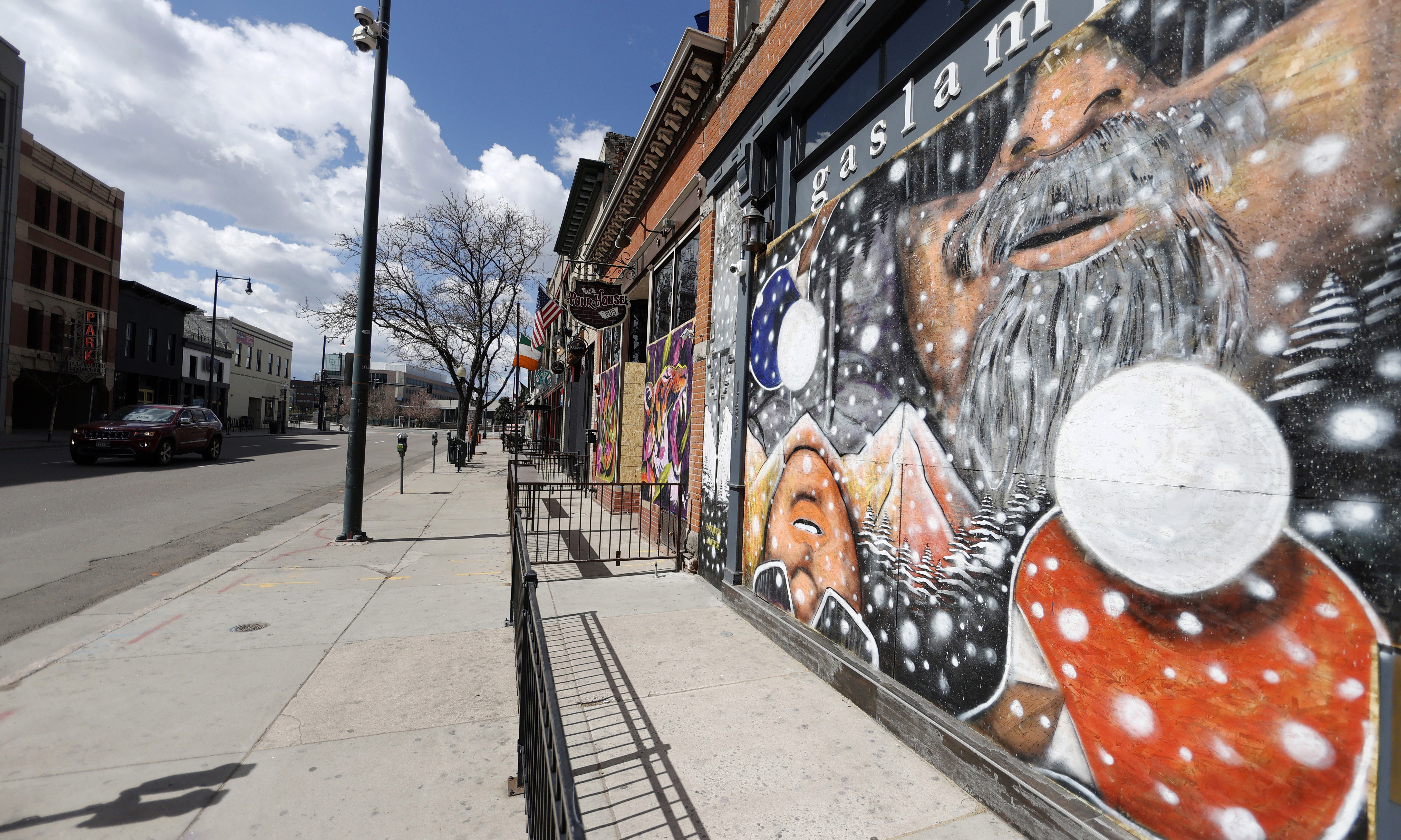 Artwork covers the plywood used to shield the windows of closed bars and restaurants on Market Street in Denver on April 25.