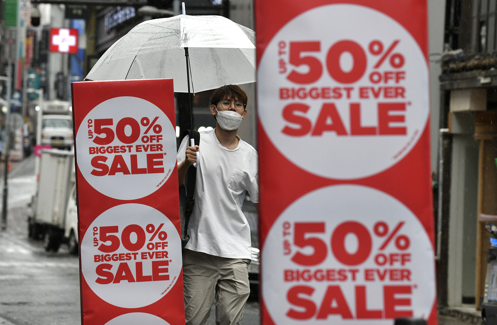 A man walks past a commercial sign at a shopping district in Seoul on July 23.