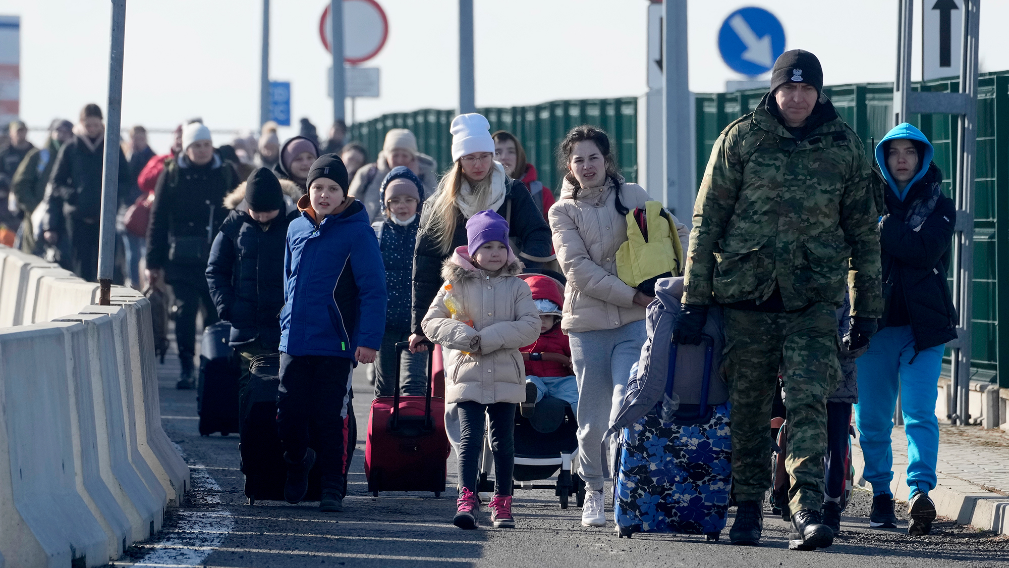 A Polish border guard assists Ukrainian refugees as they arrive to Poland, on February 26. 