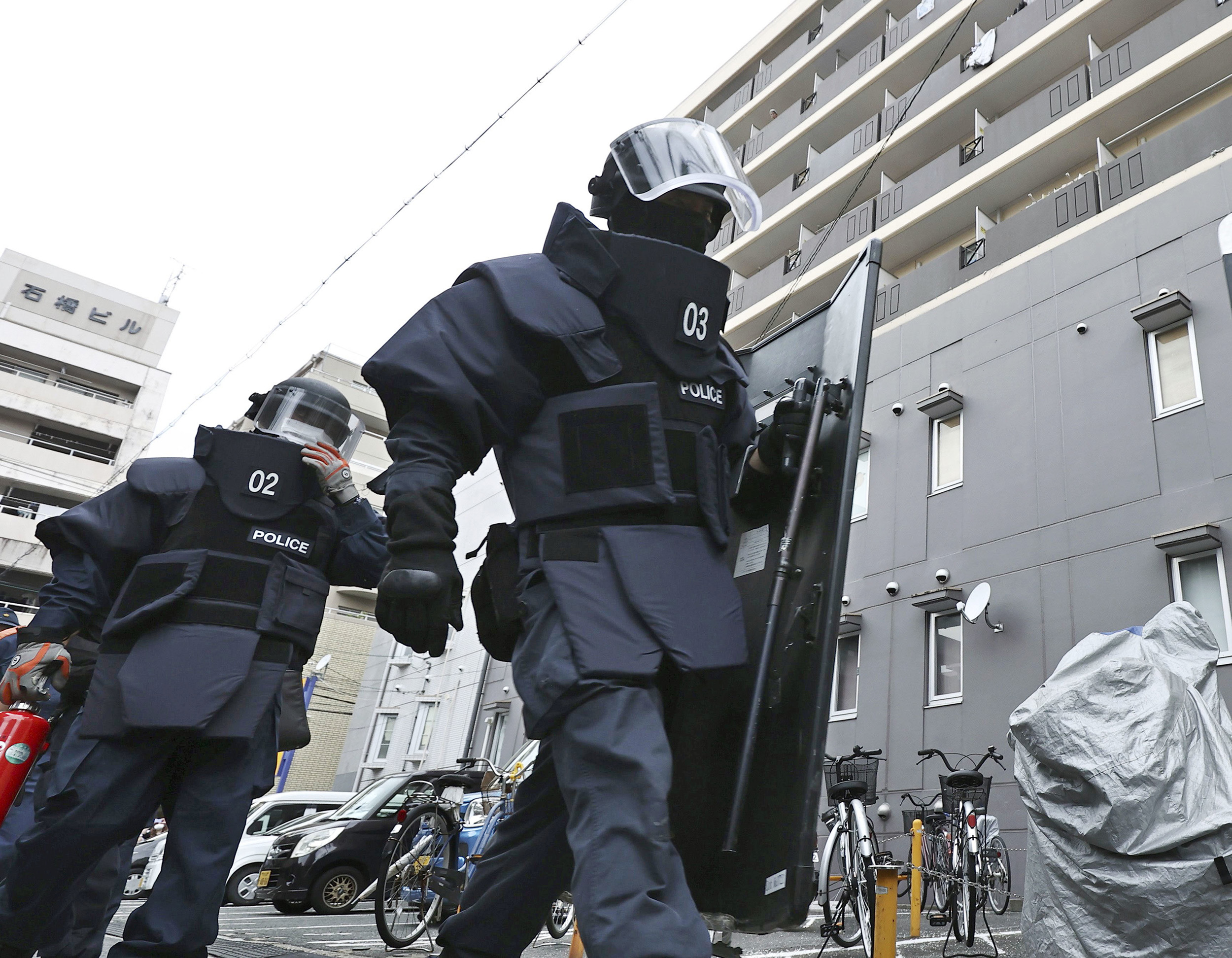 Police investigators head to a condominium owned by the man in custody for the shooting of former Japanese Prime Minister Shinzo Abe in Nara, Japan, on July 8.