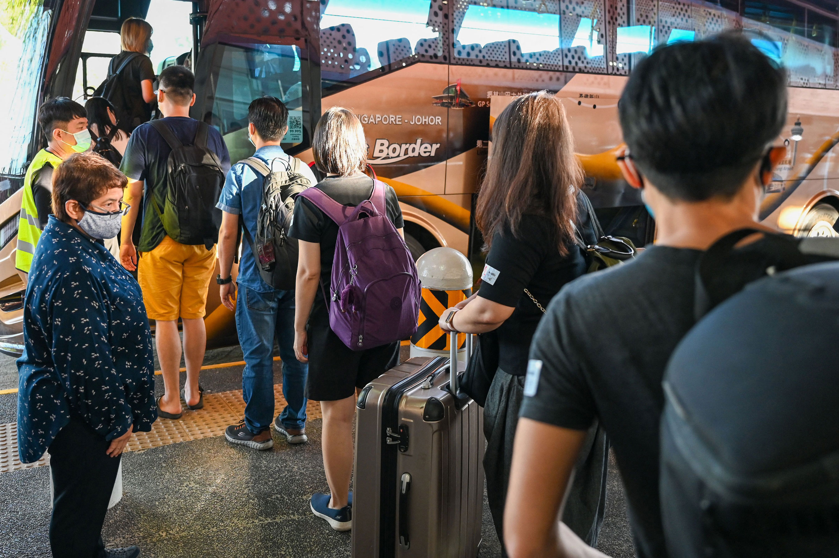 People board a bus in Singapore on November 29, under the vaccinated travel lane (VTL) for border-crossing passengers to Malaysia's southern state of Johor.