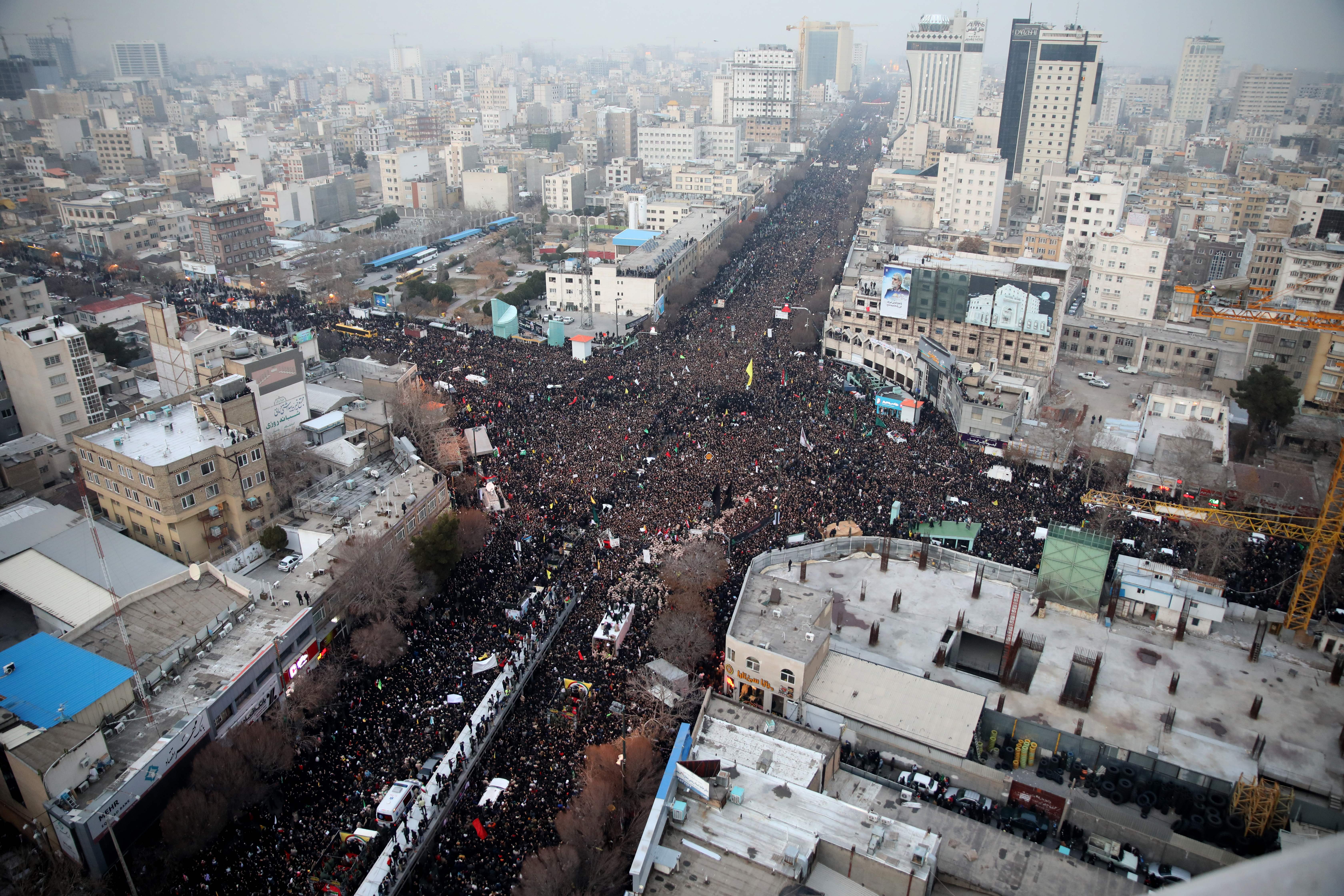  Iranians march behind a vehicle carrying the coffins of slain major general Qasem Soleimani and others as they pay homage in the northeastern city of Mashhad on Jan. 5.