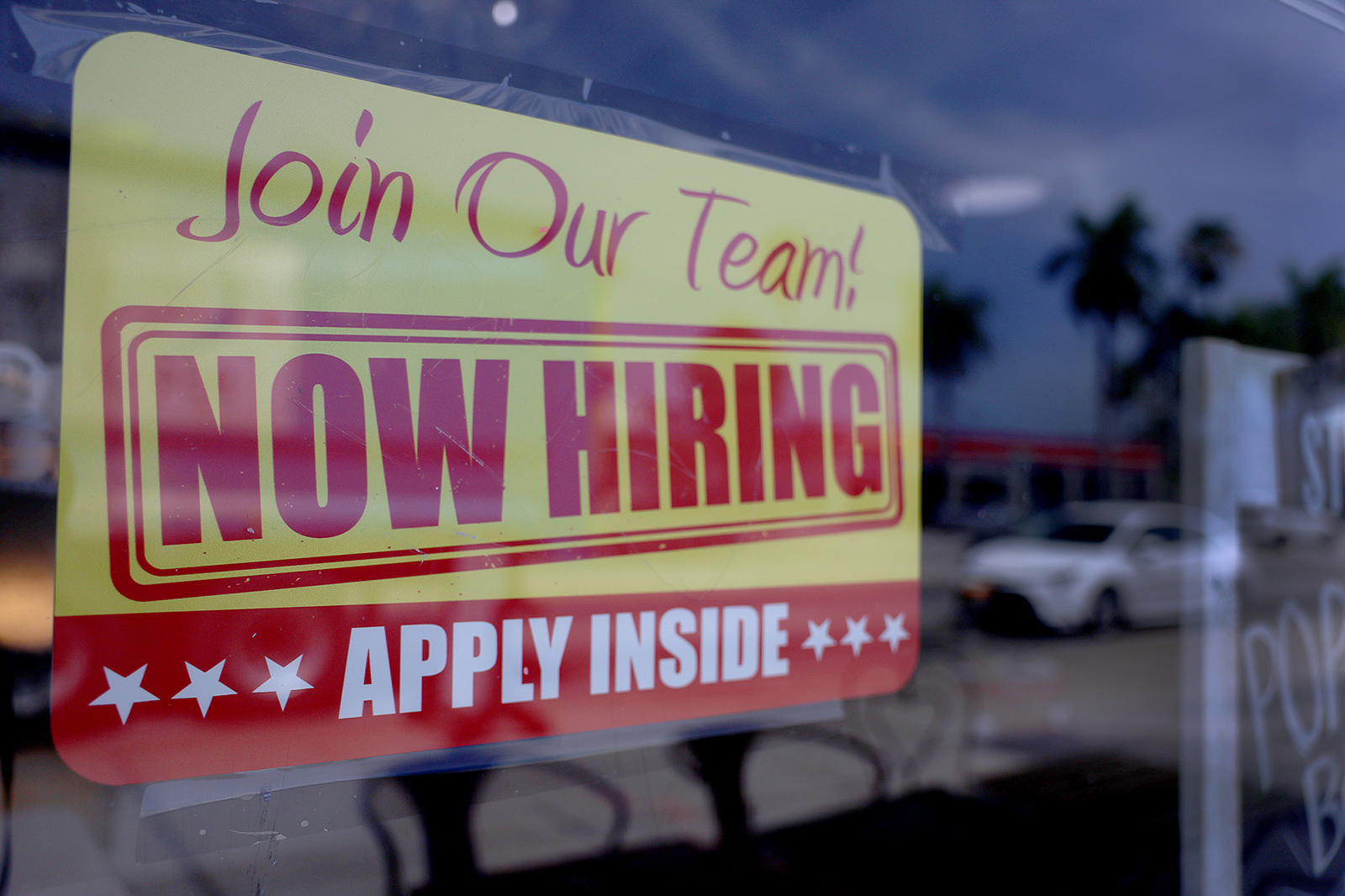 A 'Now Hiring' sign is seen posted in the window of a restaurant looking to hire workers on May 5 in Miami, Florida.