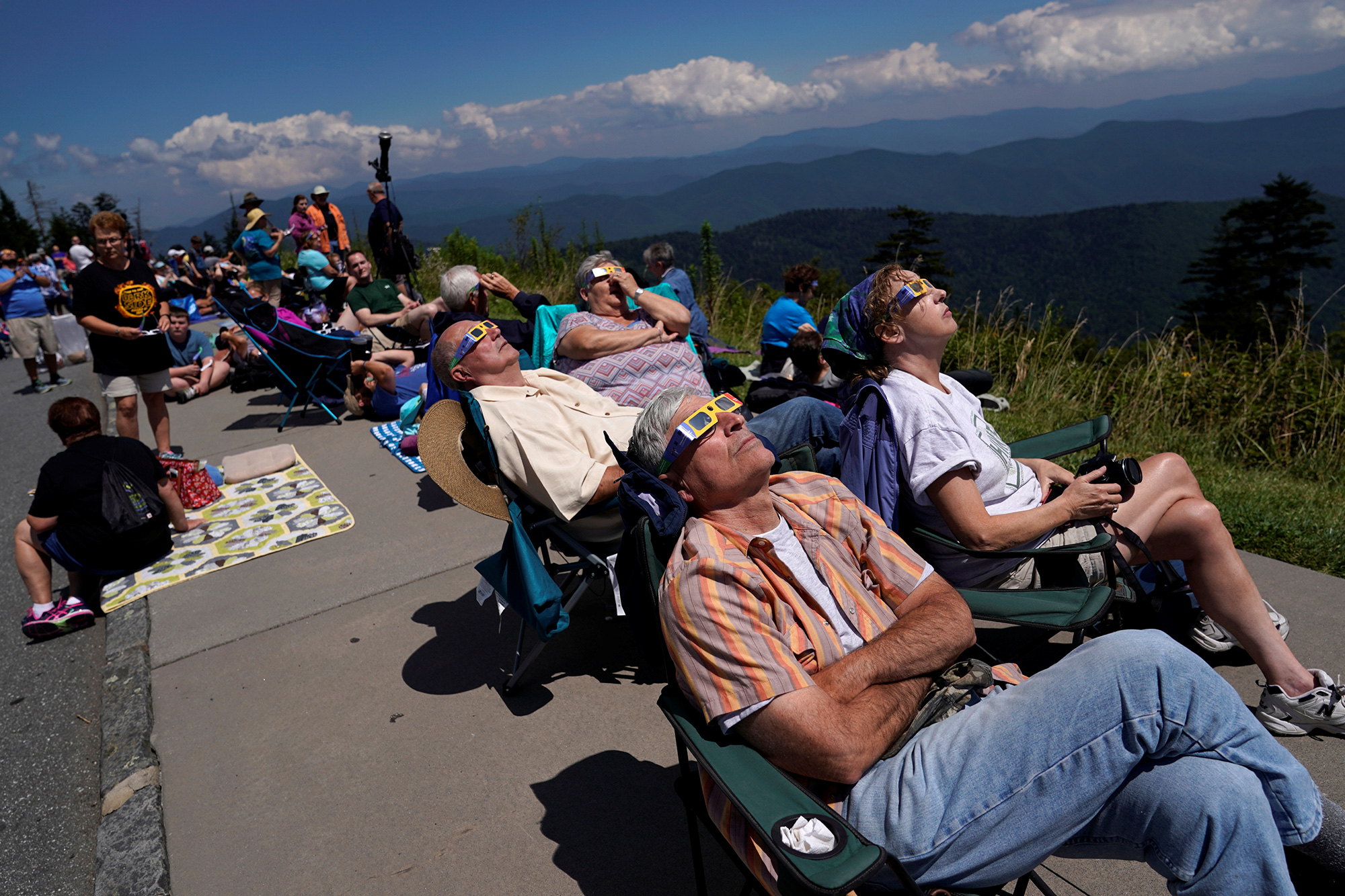 People watch as the solar eclipse approaches totality from Clingmans Dome, the highest point in Great Smoky Mountains National Park, on August 21, 2017. 