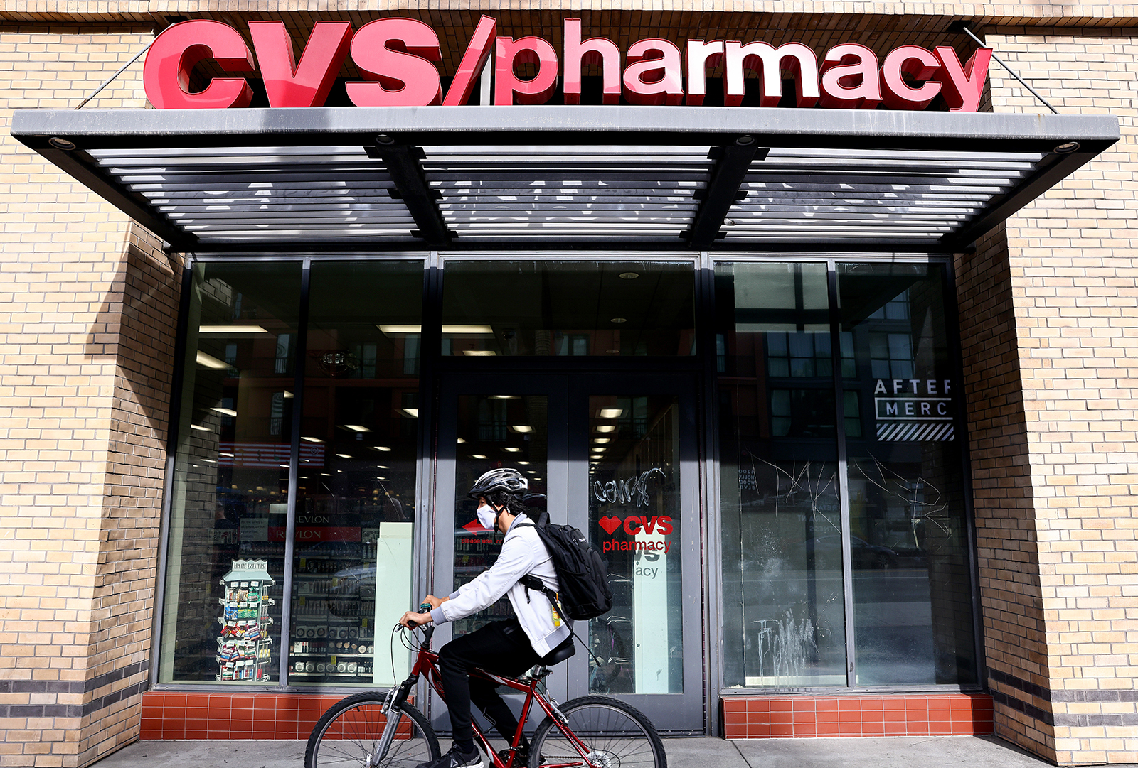A commuter rides a bike outside a CVS store on November 18, in Los Angeles.