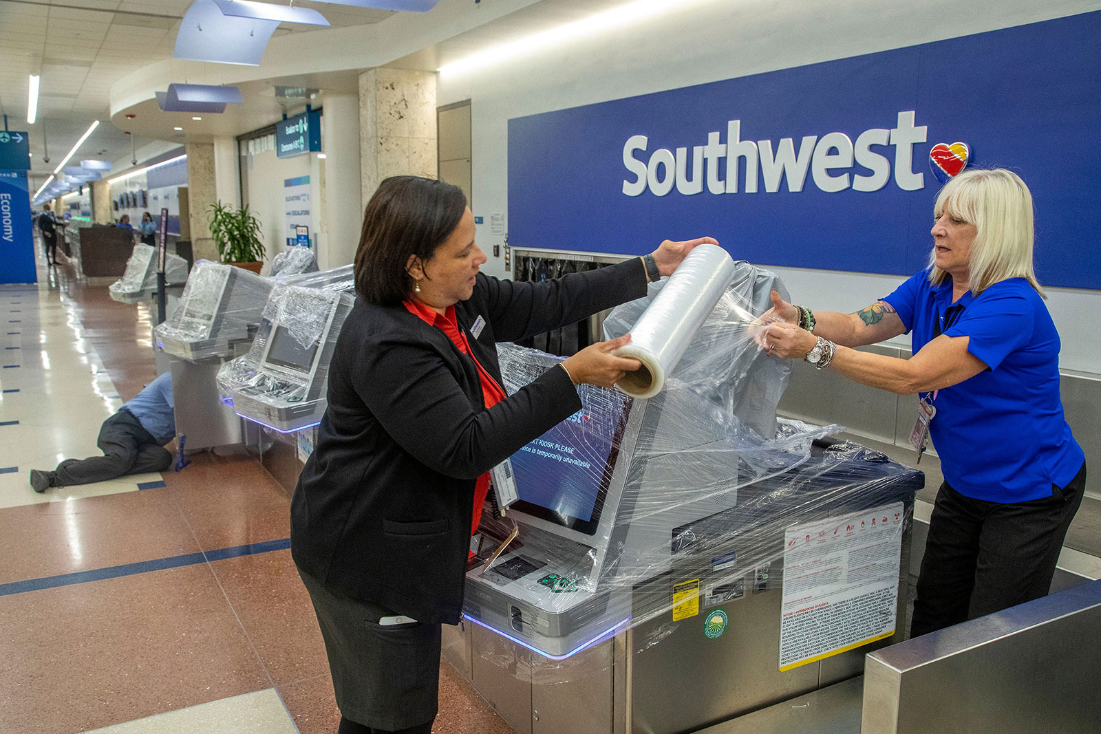 Fabiola Lindor, left, and Lisa MacNeal of Southwest Airlines cover computer systems with plastic wrap to protect them from potential leaks in West Palm Beach, Florida, on November 9.
