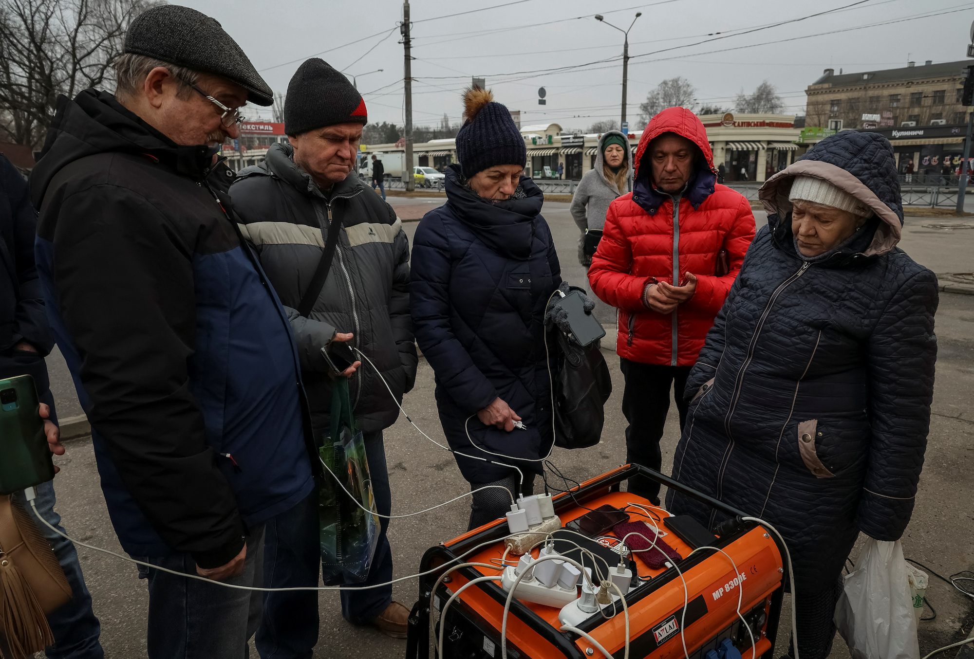 Penduduk setempat mengisi daya ponsel mereka melalui generator selama pemadaman listrik setelah infrastruktur energi terkena serangan rudal Rusia di Kharkiv pada hari Kamis.