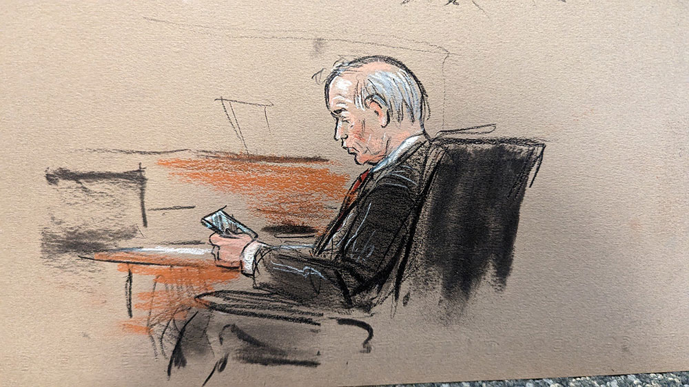 Dan Webb, attorney for Fox, looks at his phone. 