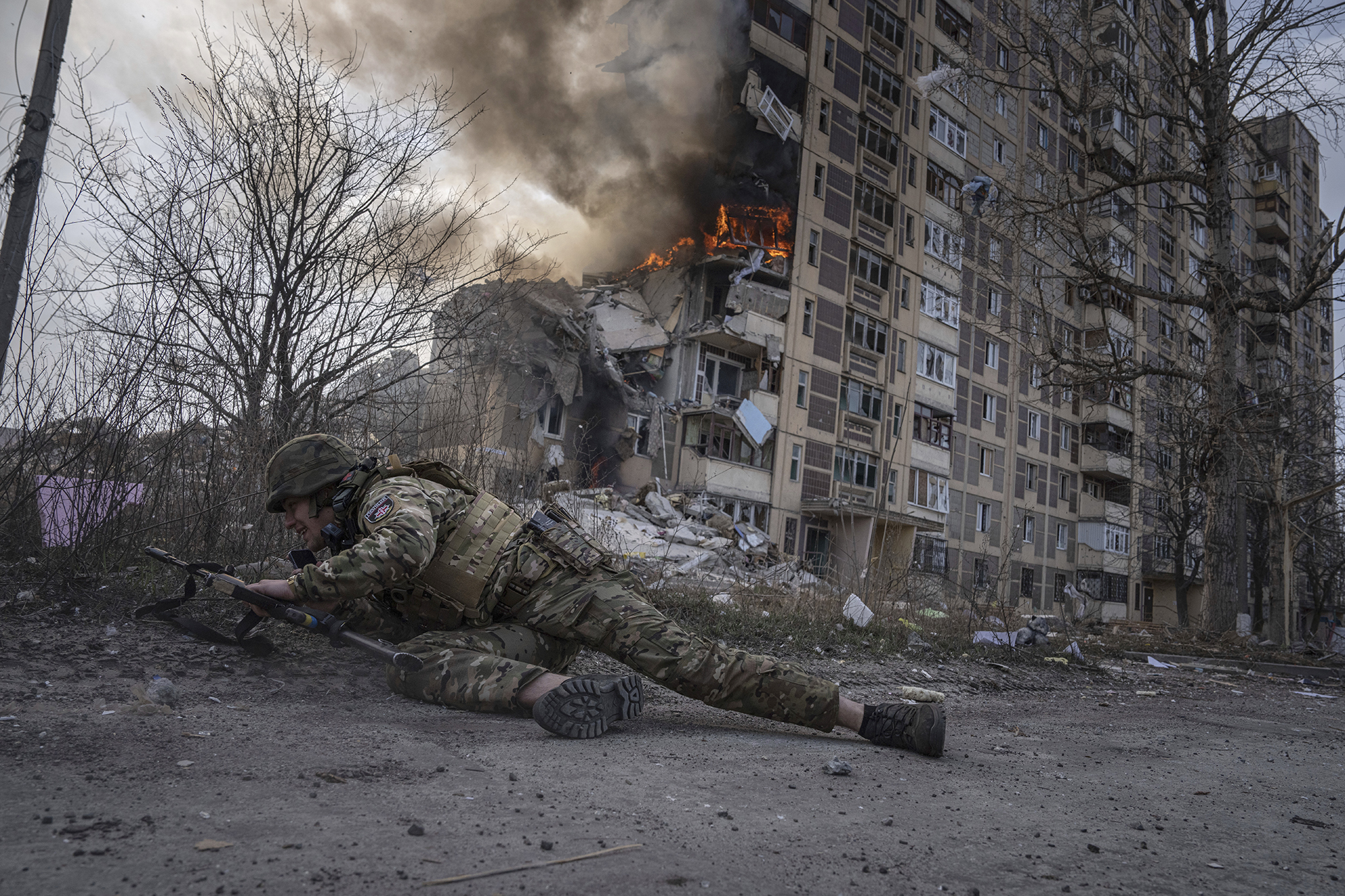 A Ukrainian police officer takes cover in front of a burning building that was hit in a Russian airstrike in Avdiivka, Ukraine, on March 17.