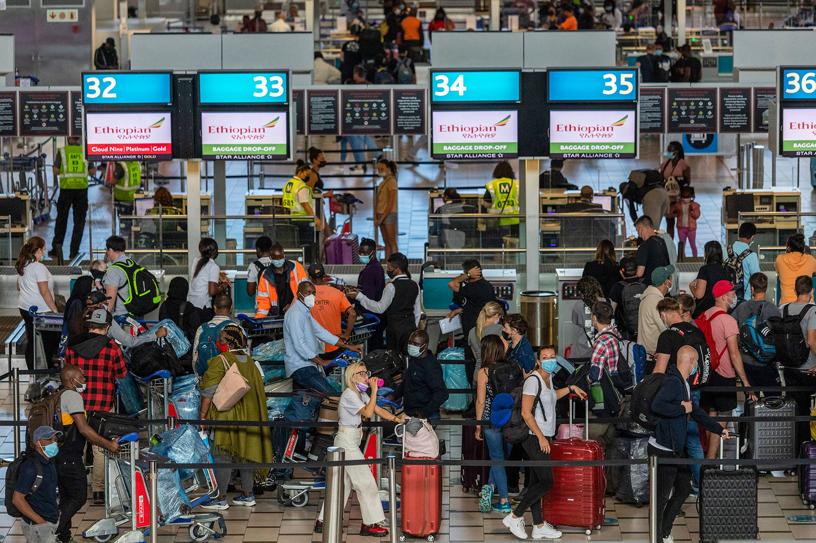 Travelers wait in line inside the departures terminal at Cape Town International Airport on December 3.