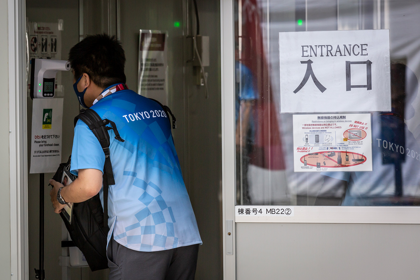 A volunteer has her body temperature checked at the entrance of Nippon Budokan on July 25 in Tokyo.