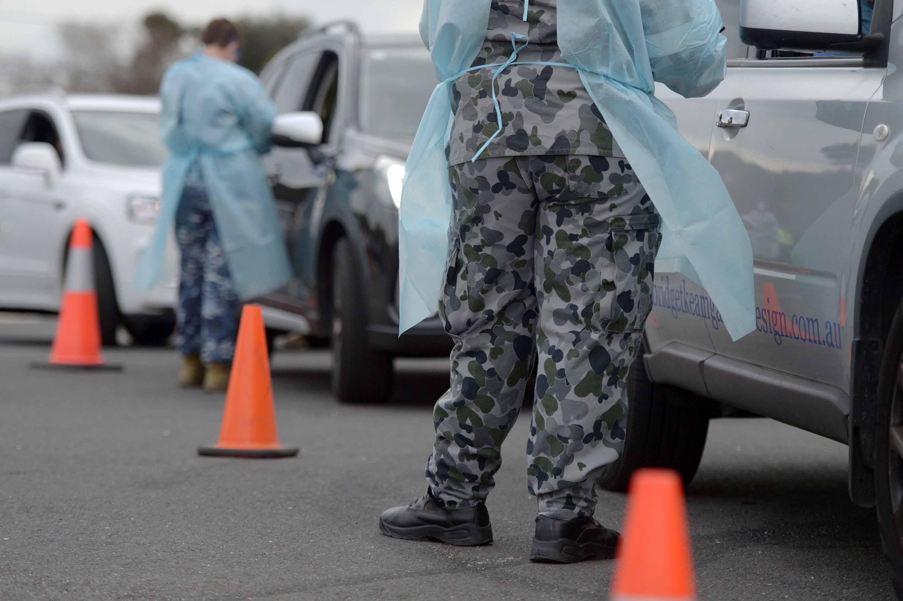 Members of the Australian Defence Force (ADF) gather information and conduct temperature checks at a drive-in Covid-19 testing site in Melbourne, Australia, on Tuesday, June 30.