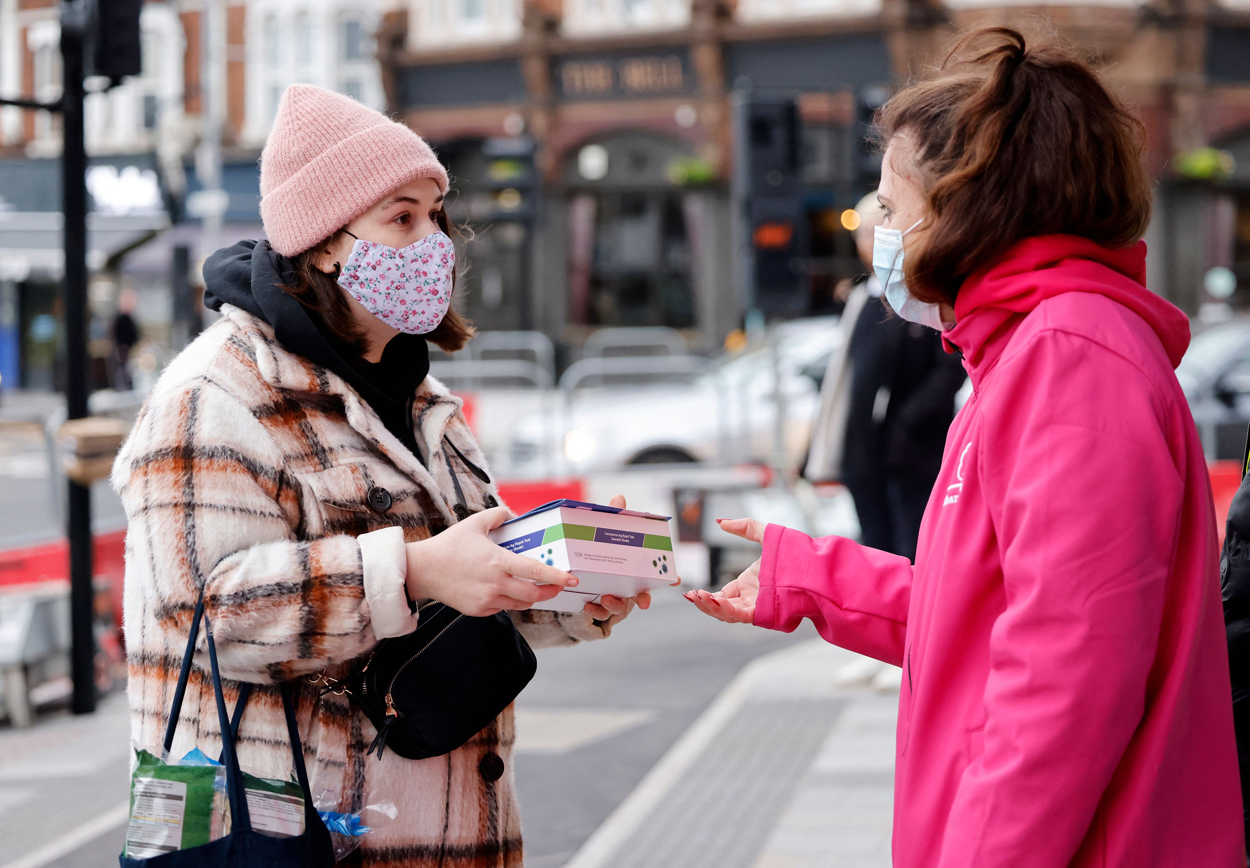 Volunteers hand out boxes of Covid-19 rapid antigen Lateral Flow Tests (LFT), in north east London on January 3, 2022. 