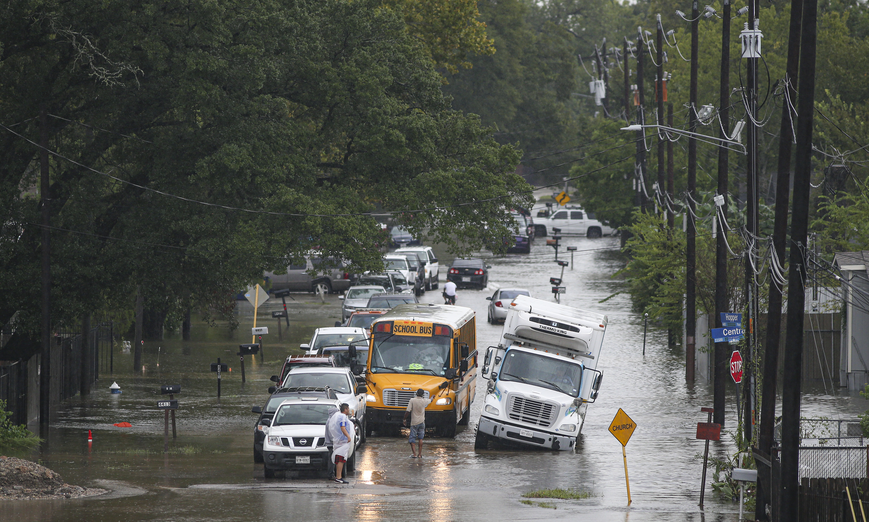 A man tries to direct a school bus on a flooded road on September 19, 2019 in Houston, Texas. 