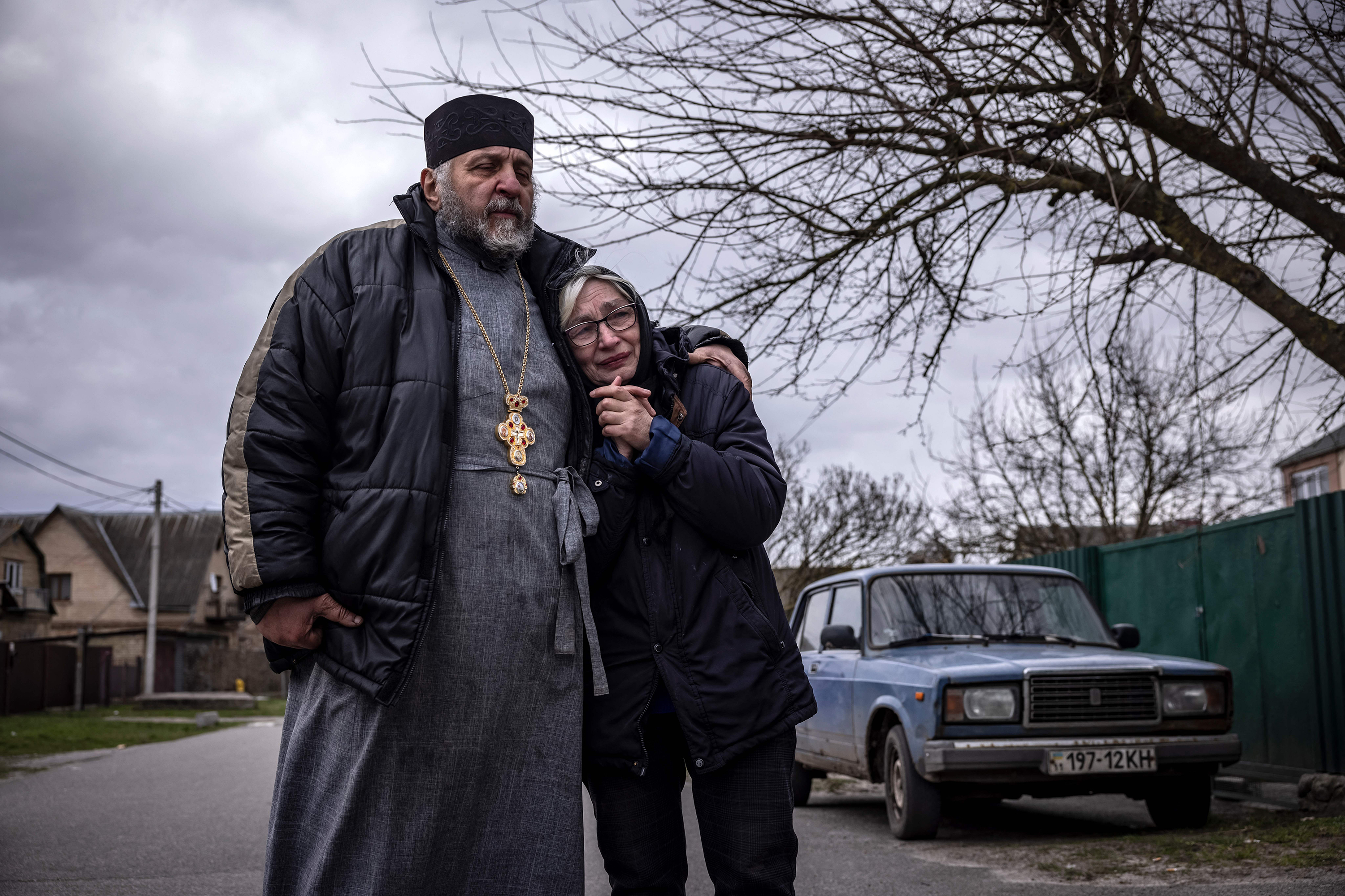 A priest and a relative of a civilian man exhumed from his yard react in Gostomel village, Kyiv on April 12.