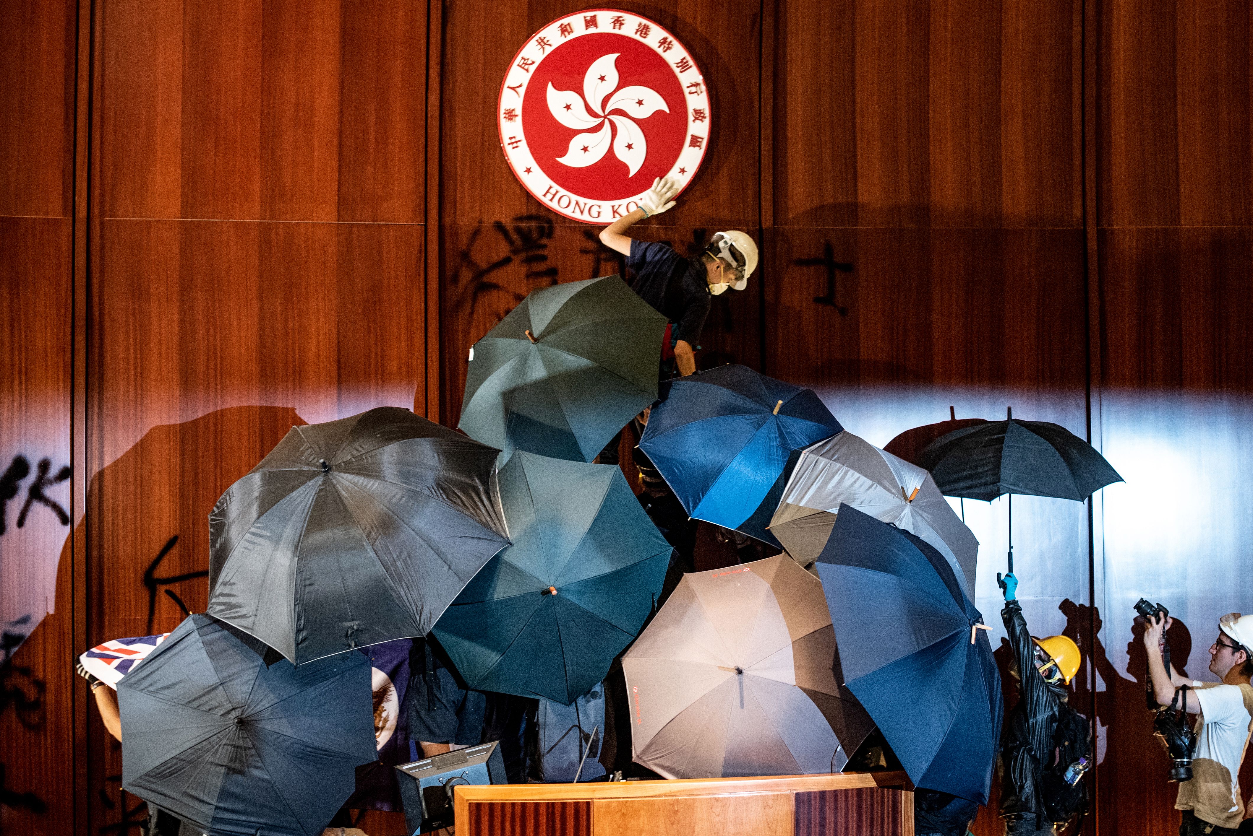 A protester defaces the Hong Kong emblem after protesters broke into the government headquarters in Hong Kong on July 1.