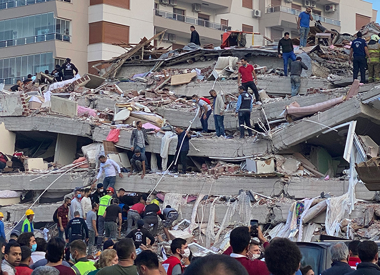 Rescue workers and local people try to save residents trapped in the debris of a collapsed building, in Izmir, Turkey, Friday, Oct. 30, 2020. 