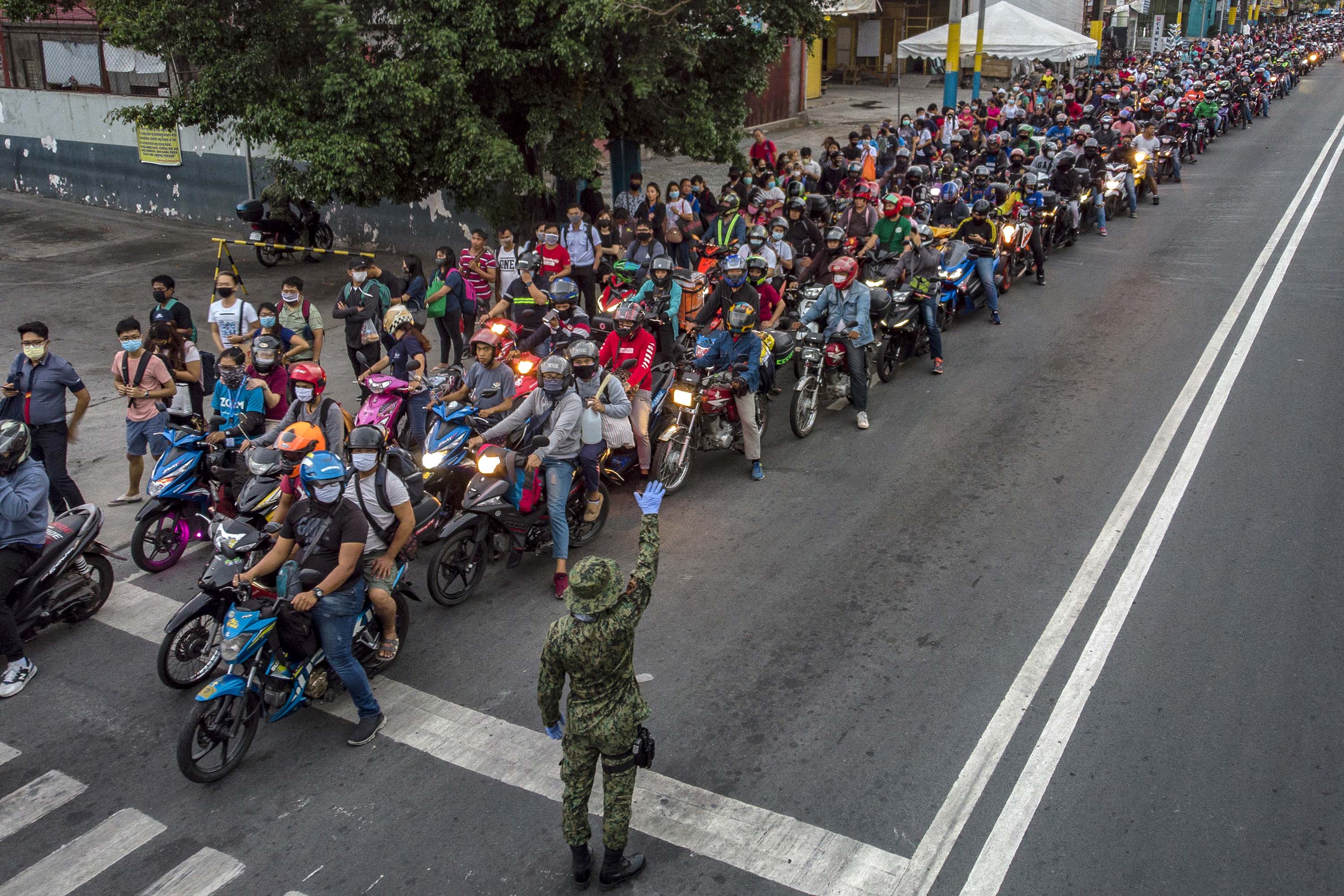 Motorists queue at a health checkpoint on the outskirts of Manila, Philippines, on March 16.
