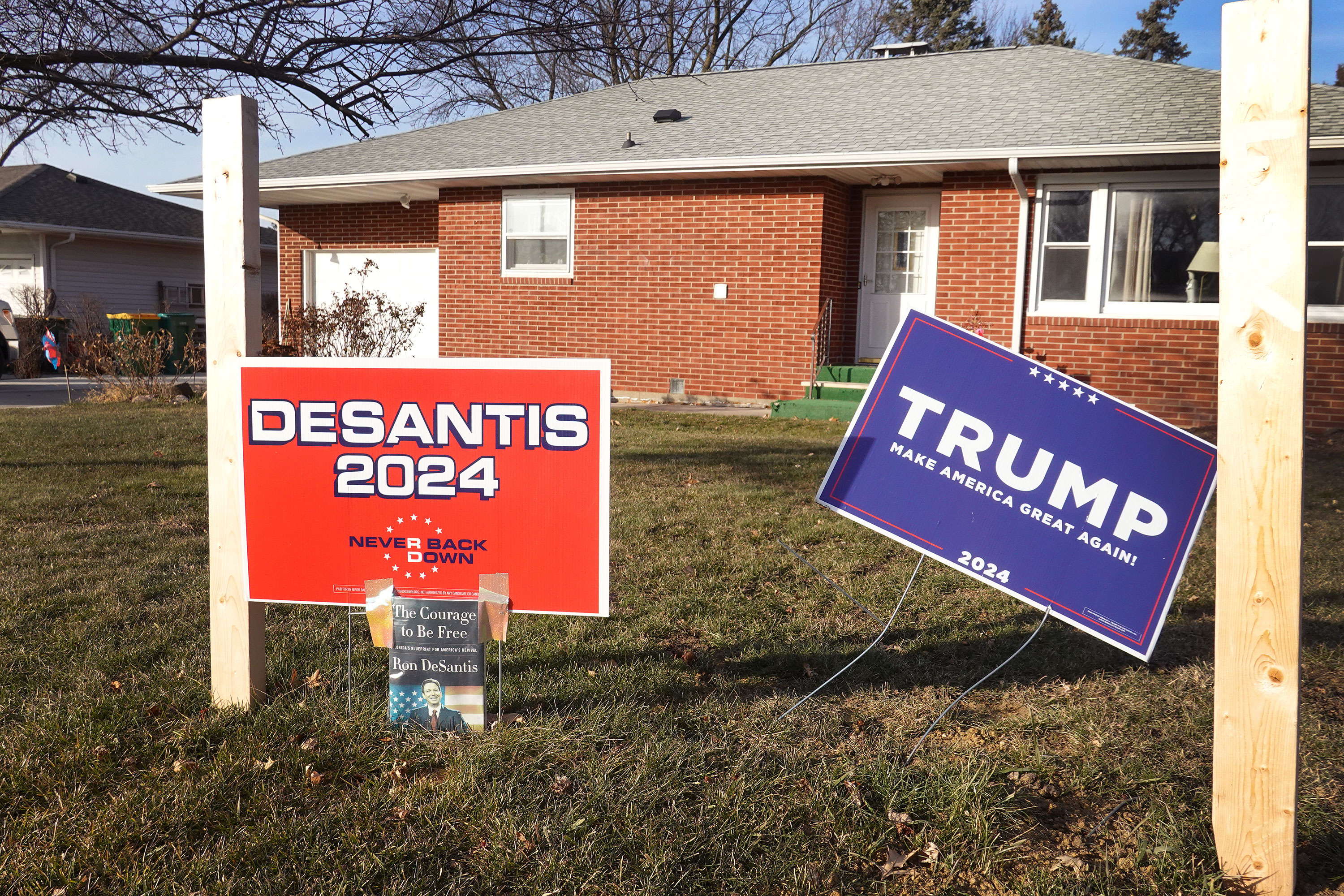 A husband and wife show their dueling support with campaign signs in front of their home in Winthrop, Iowa, on December 20.