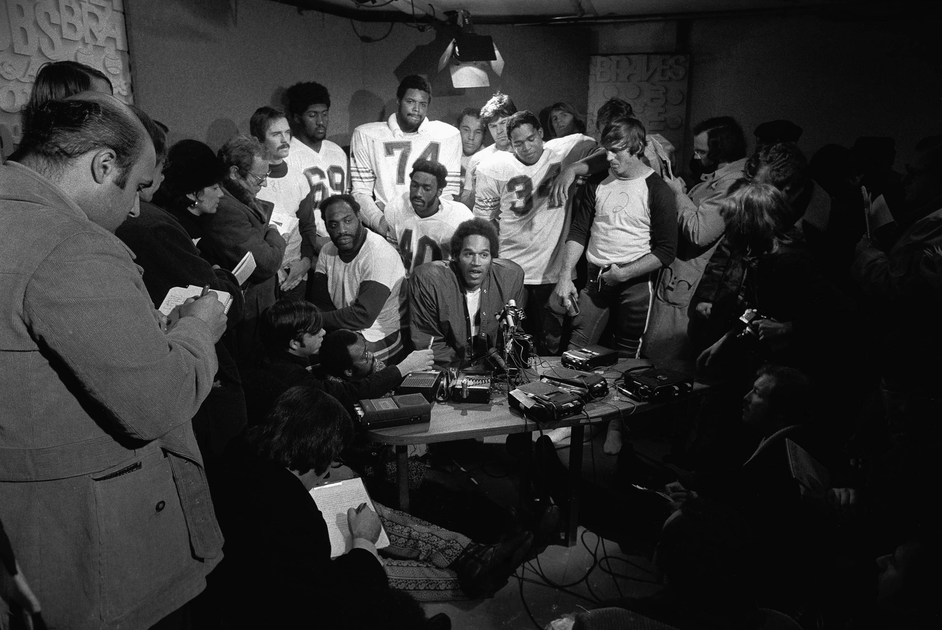 O.J. Simpson speaks to the press with members of the Buffalo Bills gathered around following his record-breaking performance in a game in 1973.