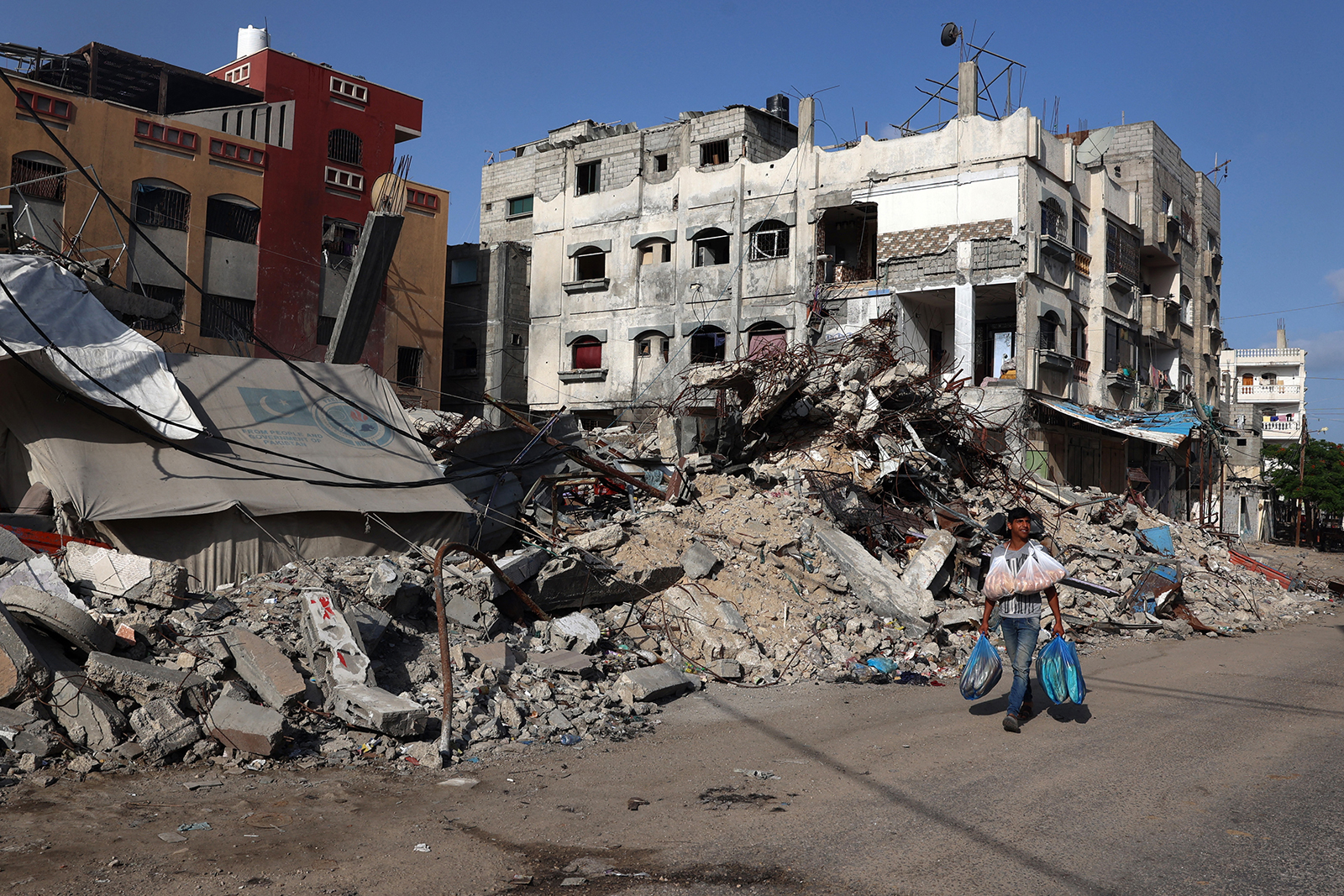 A Palestinian man walks past a destroyed building in Rafah in the southern Gaza Strip on May 26.