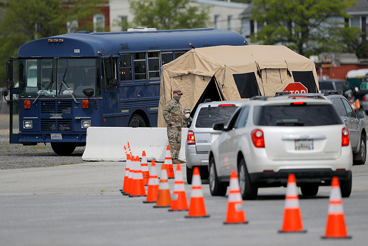 A Maryland National Guard member checks vehicles entering a drive-through coronavirus testing facility in a parking lot at Pimlico Race Course on Friday, May 15, in Baltimore. 