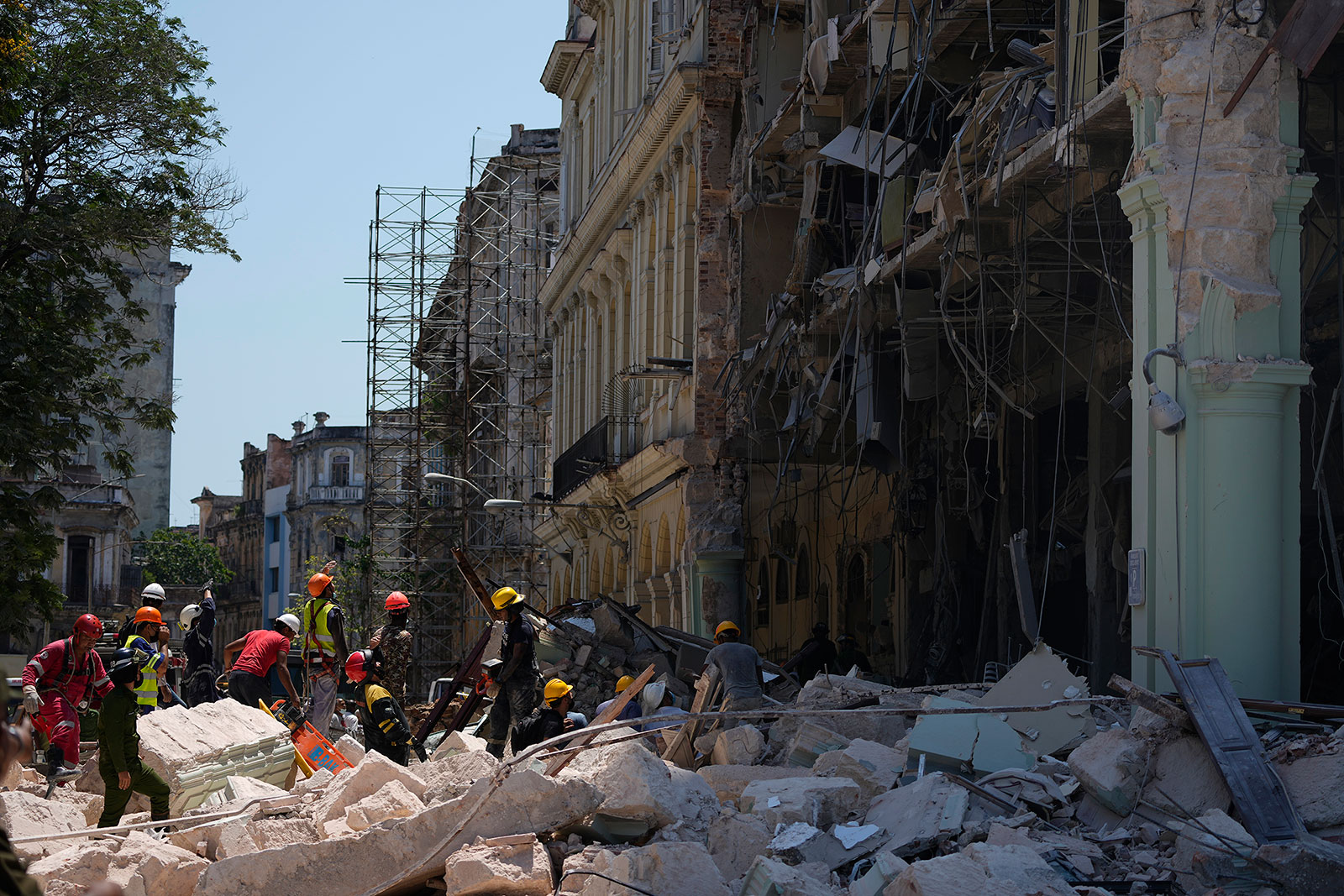 Emergency workers walk amid the rubble outside the Hotel Saratoga after an explosion in Havana on May 6.