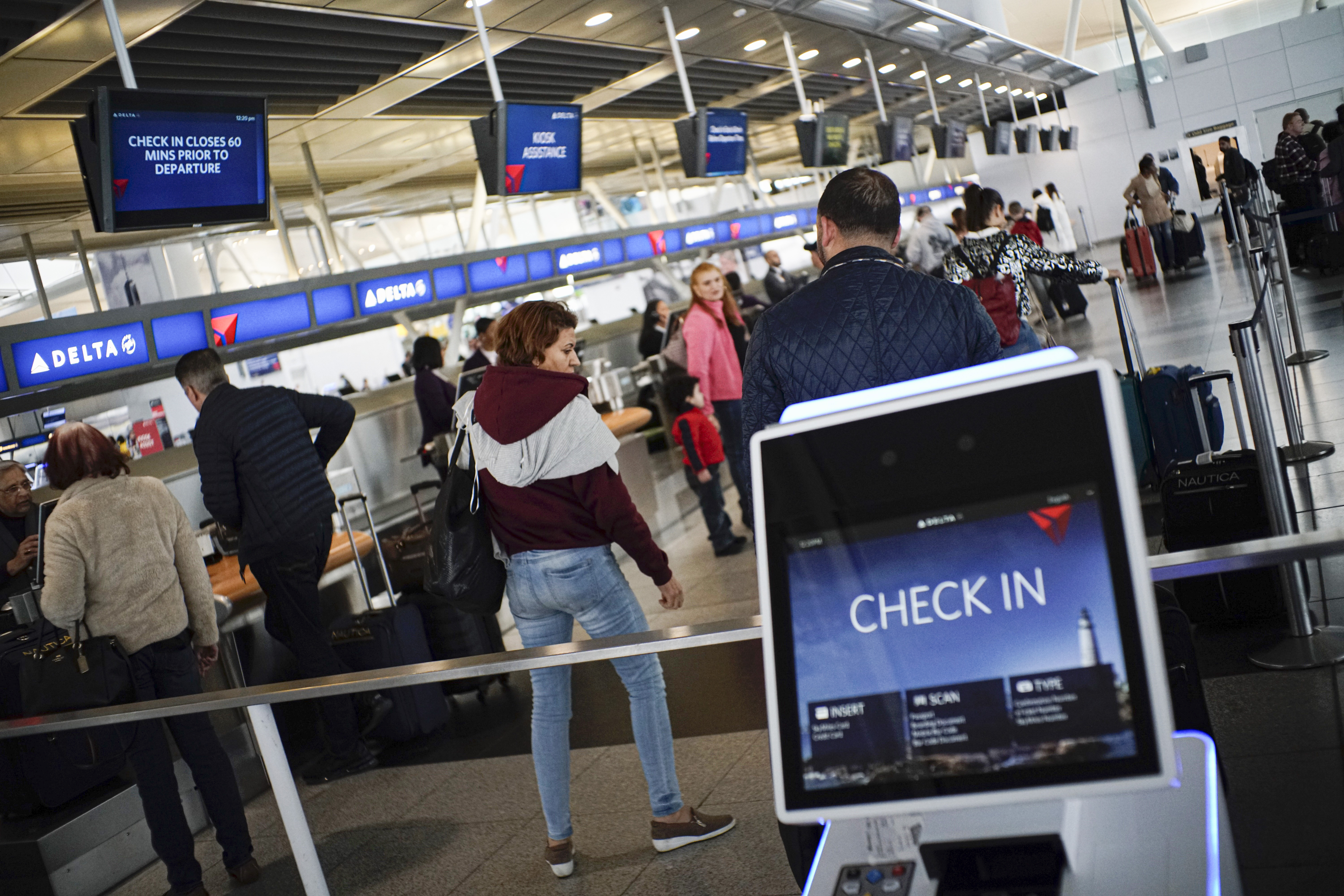 People check in at the Delta counter inside the John F. Kennedy International Airport in New York on Tuesday, March 3.
