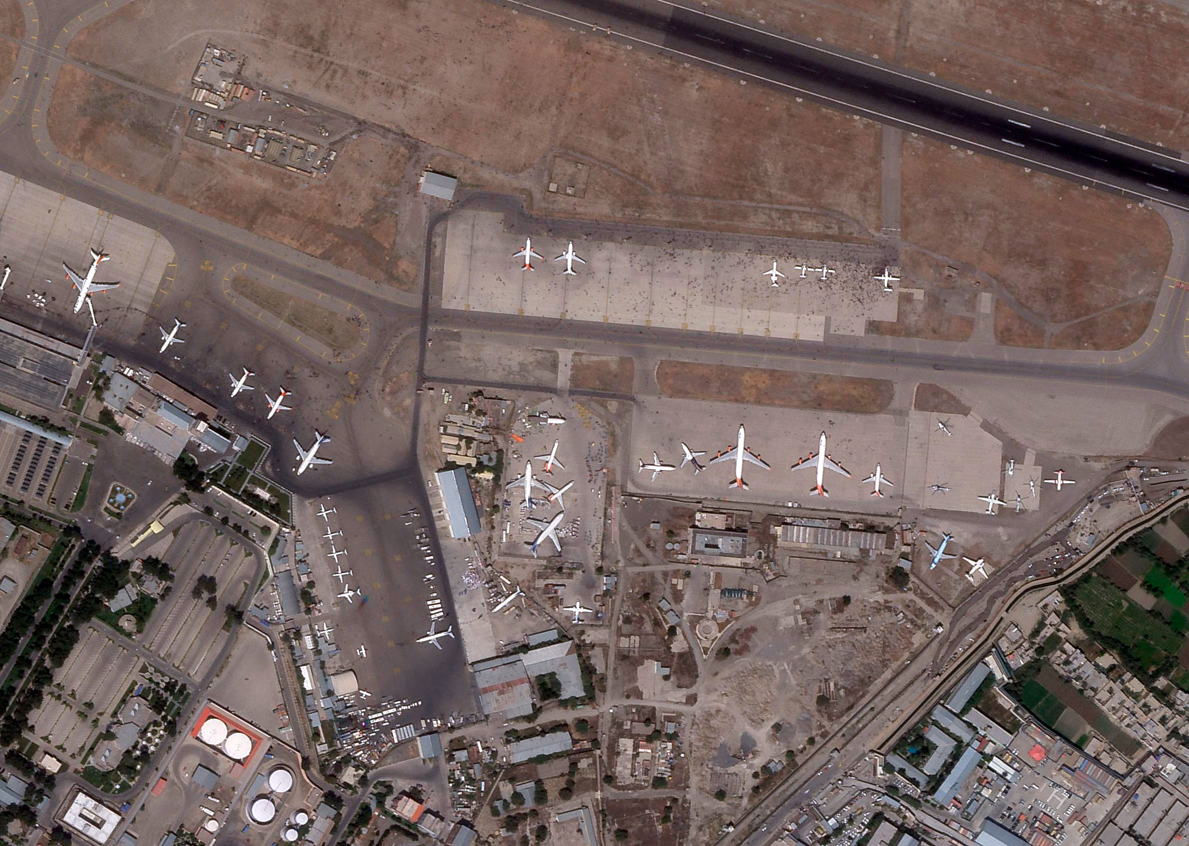 Cette image satellite de Planet Labs montre des personnes sur le tarmac de l'aéroport international Hamid Karzai de Kaboul, en Afghanistan, le 16 août 2021.