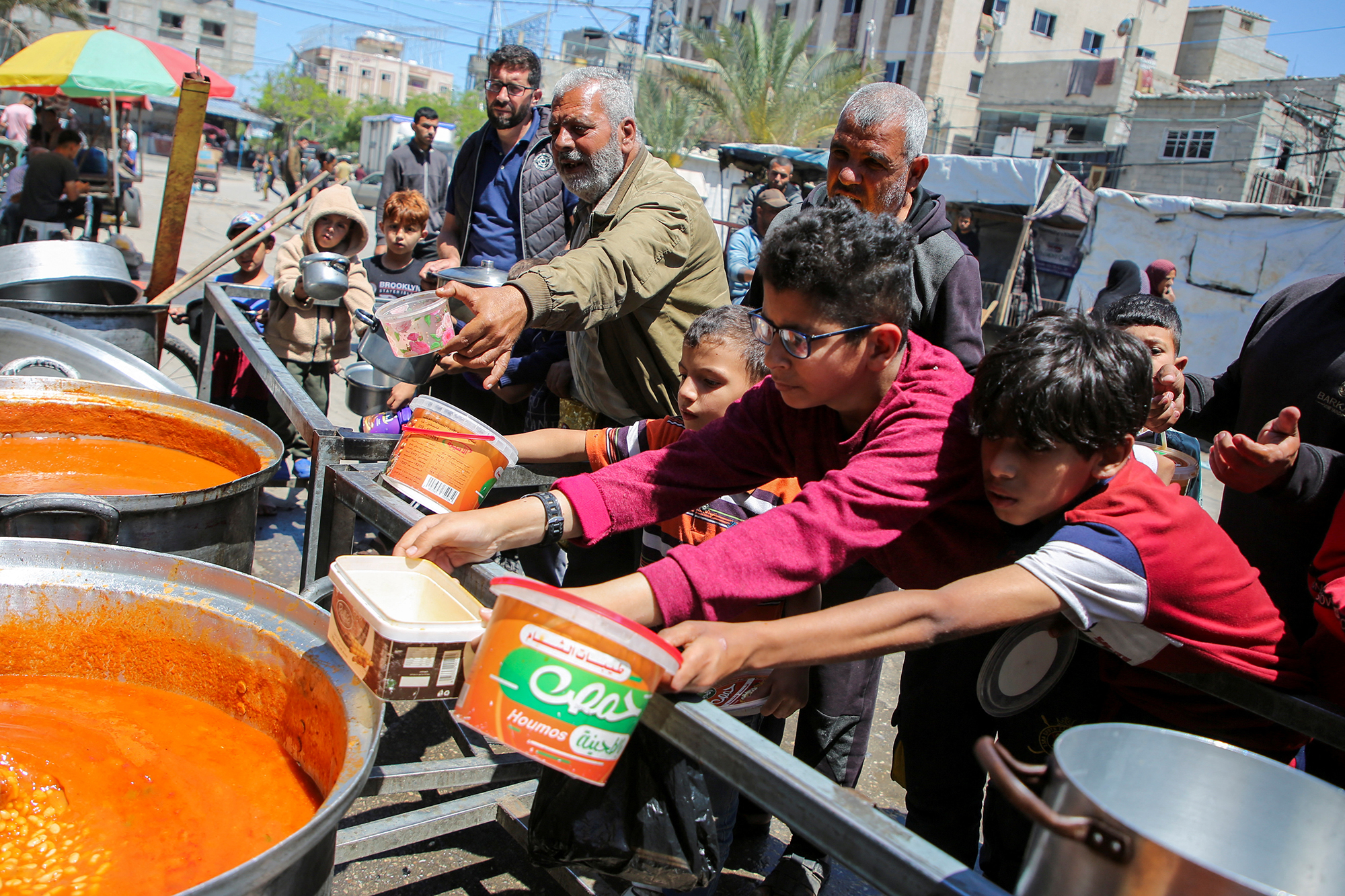 Palestinians gather to receive food cooked by a charity kitchen in the eastern part of Rafah, Gaza, on May 8.