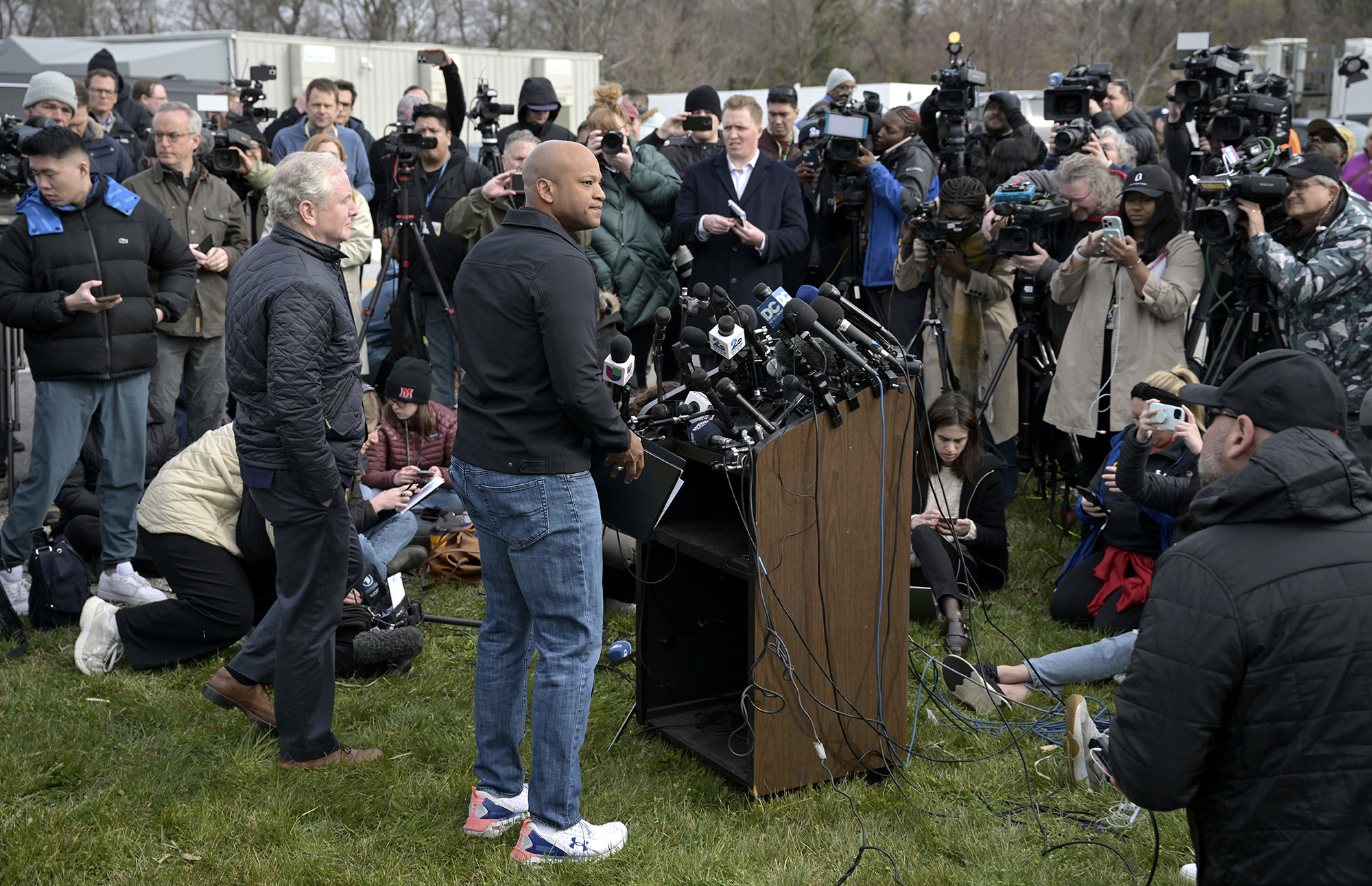 Wes Moore, center, holds a news conference near the scene where a container ship collided with a support on the Francis Scott Key Bridge, on March 26.
