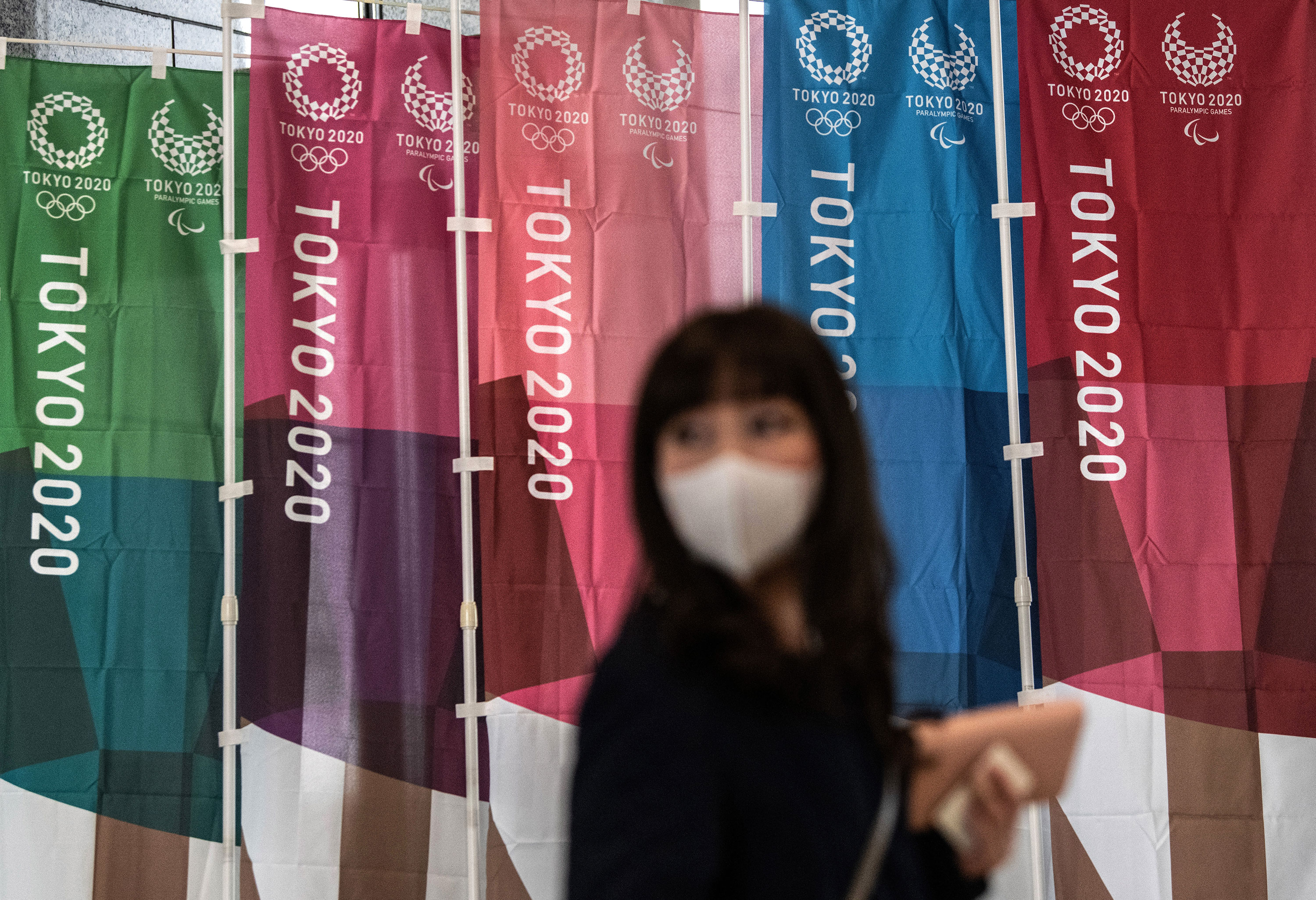 A woman walks past Tokyo 2020 Olympics banners on March 19 in Tokyo, Japan. 