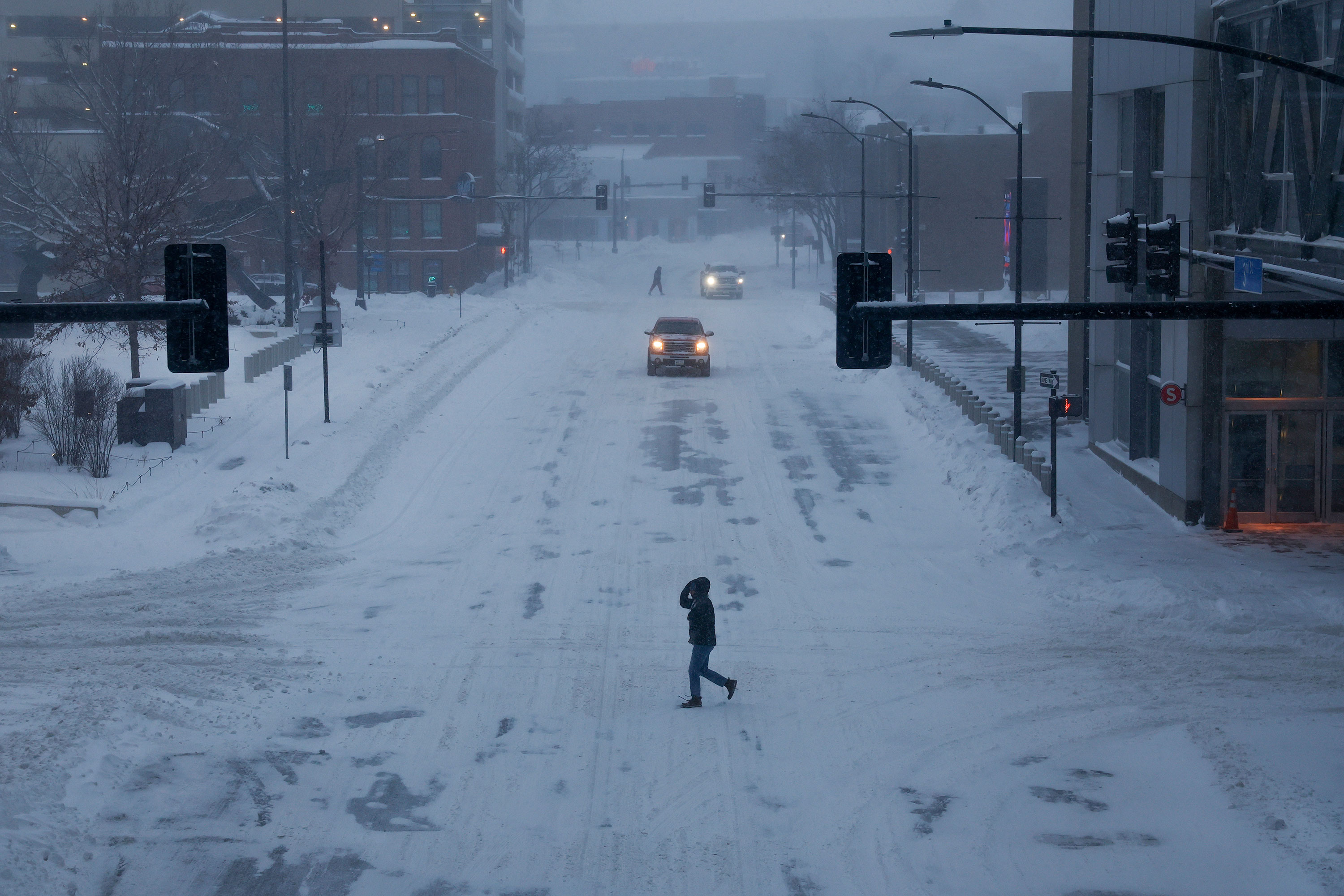 A person crosses a snow covered street in Des Moines, Iowa, on Friday. 