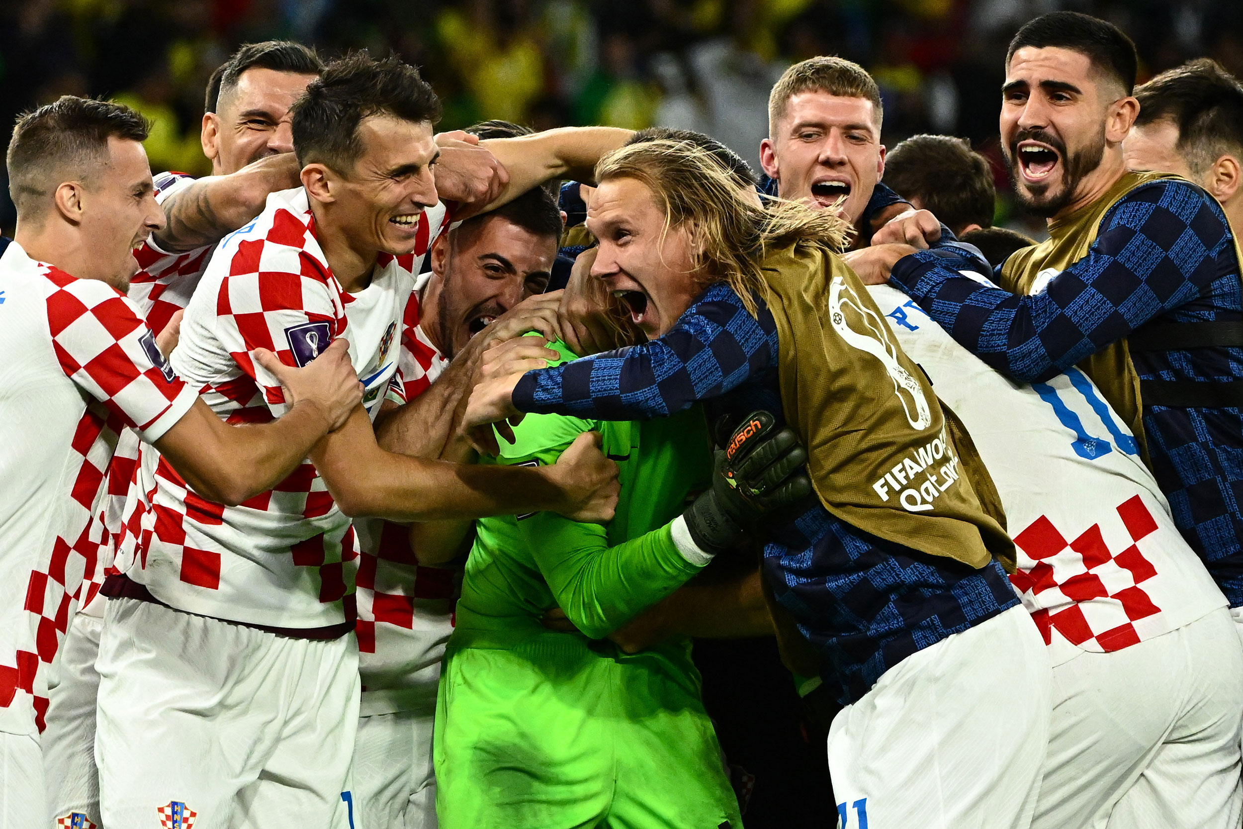 Teammates swarm Livaković after Croatia's victory.