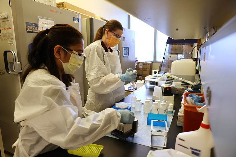 Medical lab scientists, Glenda Daza, left, and Emily Degli-Angeli, work on samples collected in the Novavax Phase 3 Covid-19 clinical vaccine trial at the UW Medicine Retrovirology Lab at Harborview Medical Center on February 12, in Seattle, Washington. 