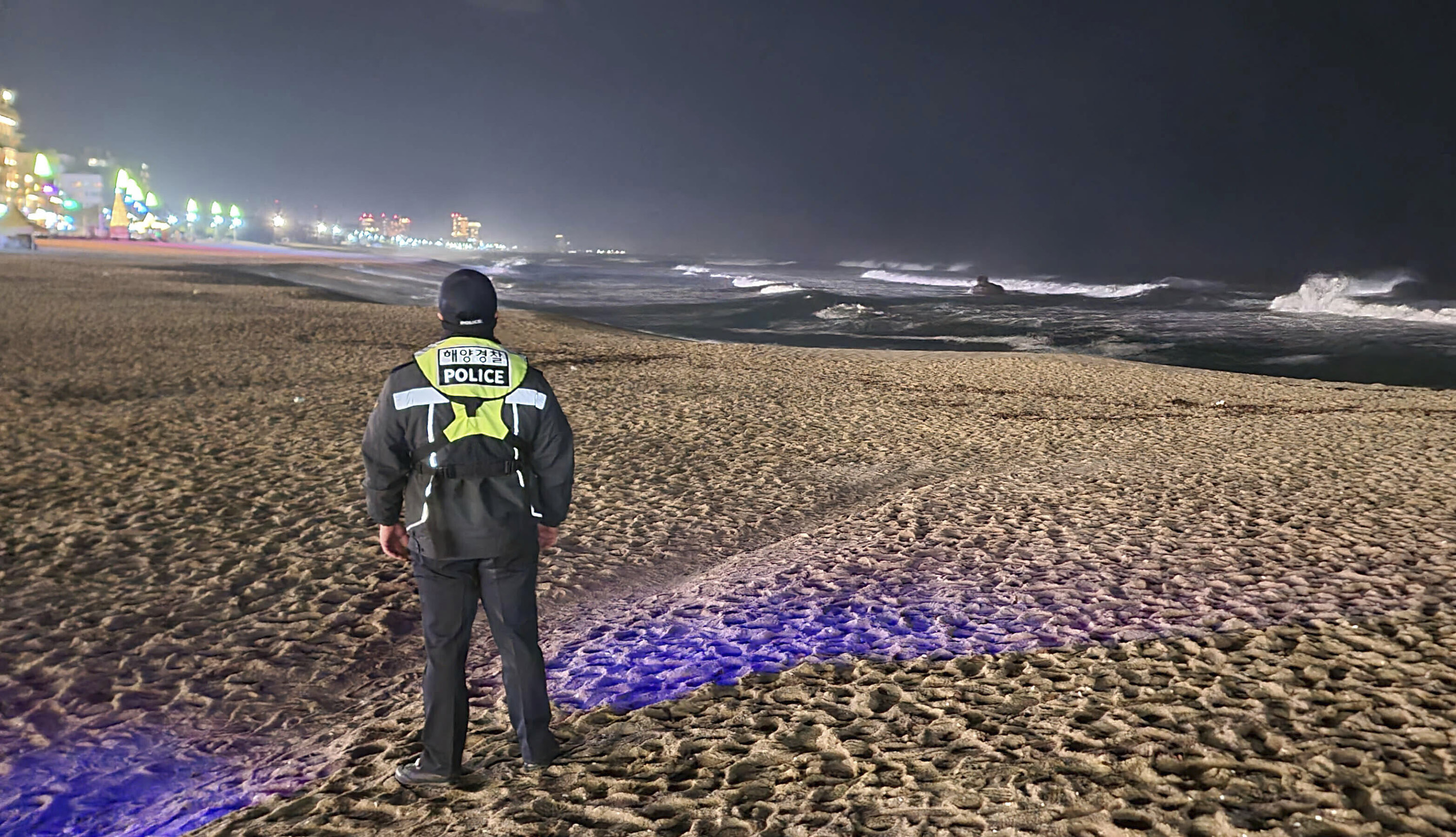 A member of the coast guard patrols a beach in Gangneung, South Korea, monitoring for possible sea level changes, on Monday, January 1.