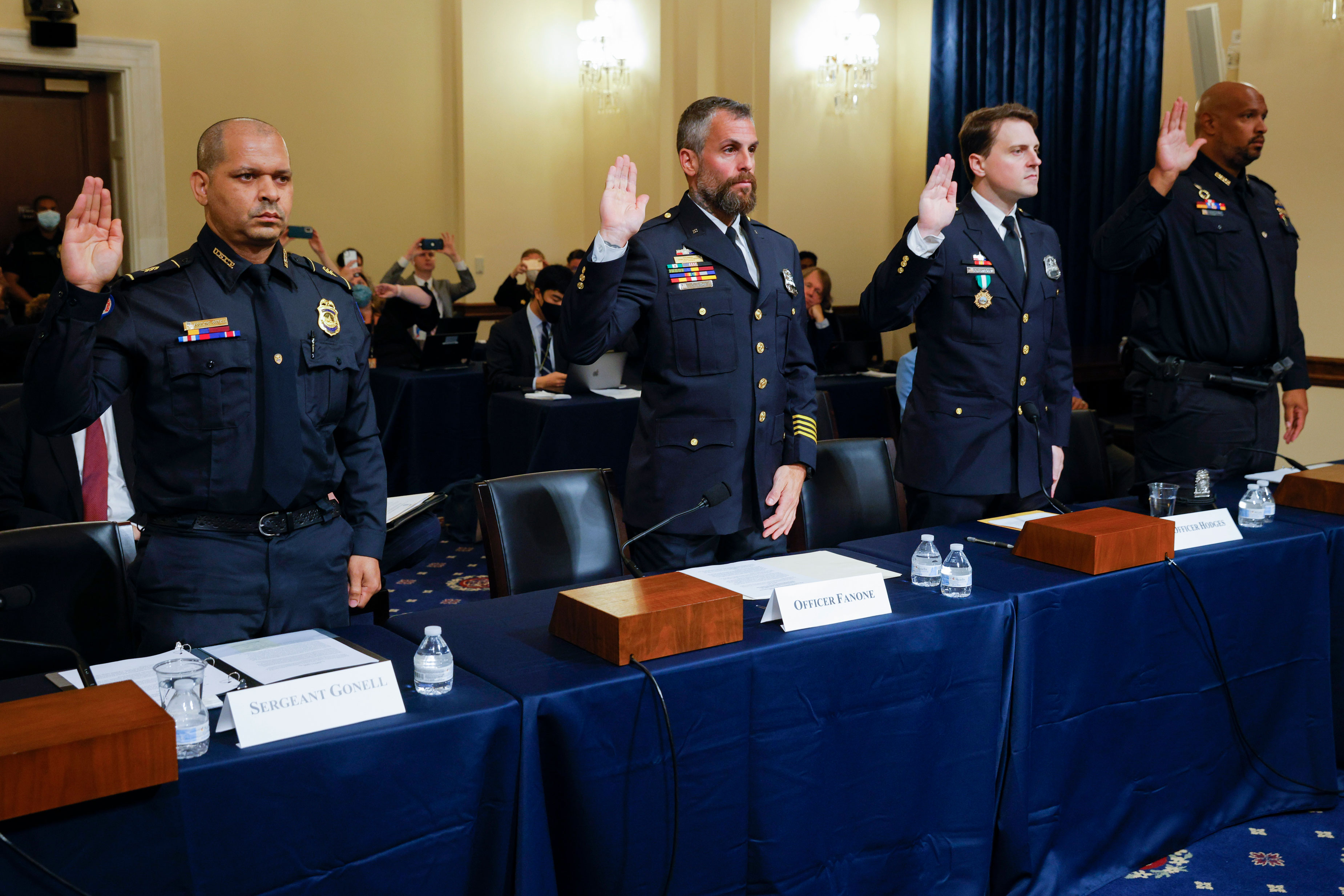 From left, US Capitol Police Sgt. Aquilino Gonell, DC police officer Michael Fanone, DC police officer Daniel Hodges, and US Capitol police officer Harry Dunn are sworn in to testify to the House select committee hearing on the January 6 attack on Capitol Hill on Tuesday, July 27.