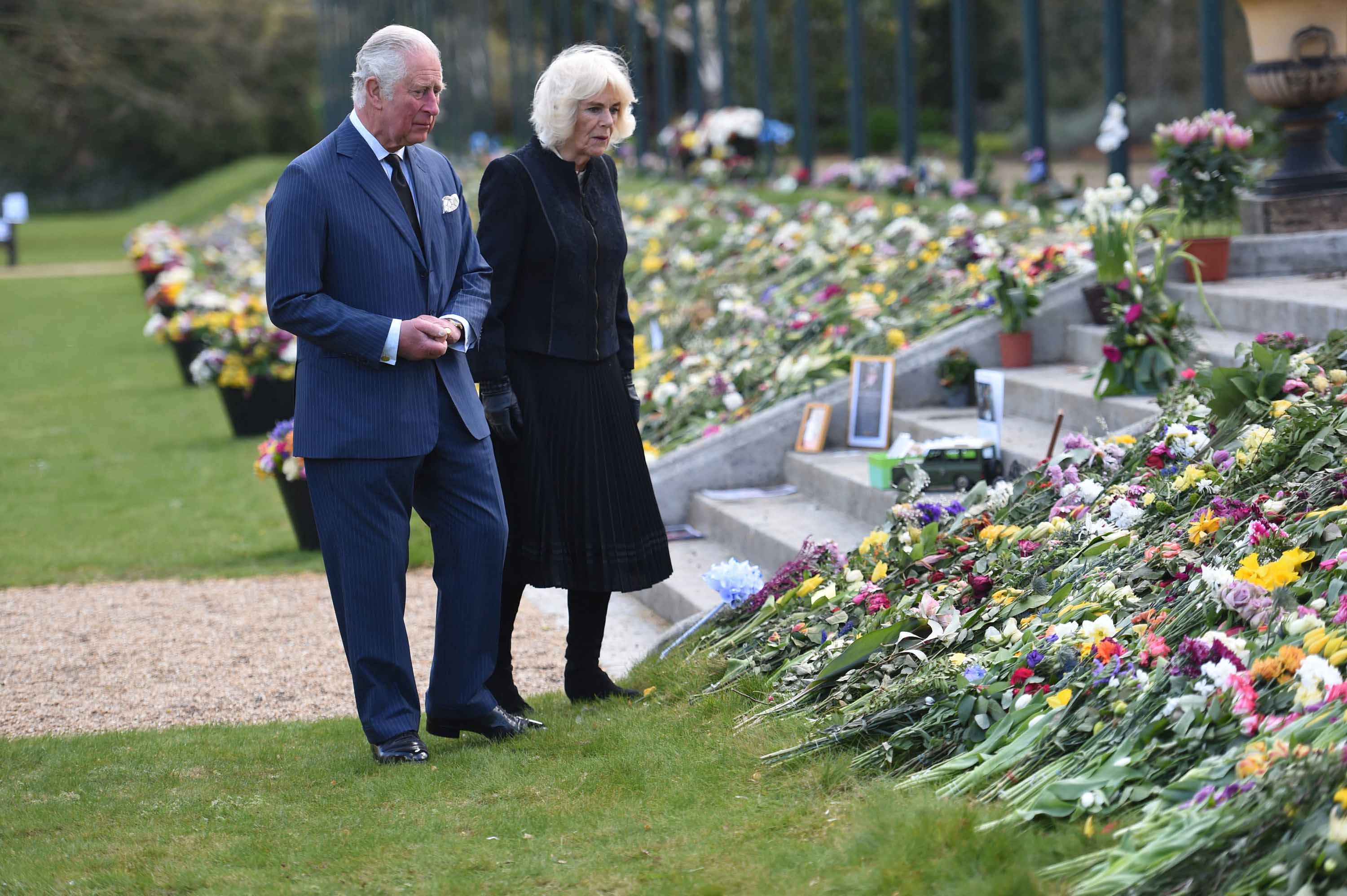 Britain's Prince Charles, Prince of Wales and Britain's Camilla, Duchess of Cornwall visit the gardens of Marlborough House in London on April 15, to view flowers and messages of condolence left by members of the public outside Buckingham Palace. 