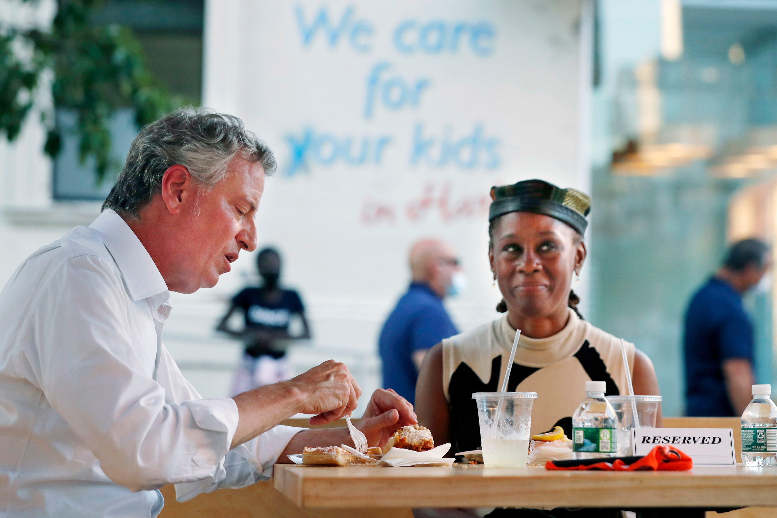 New York Mayor Bill de Blasio, left, dines with his wife Chirlane McCray in an outdoor booth at Melba's restaurant in Harlem on the first day of the Phase 2 reopening of the city during the coronavirus pandemic Monday, June 22, 2020, in New York. (AP Photo/